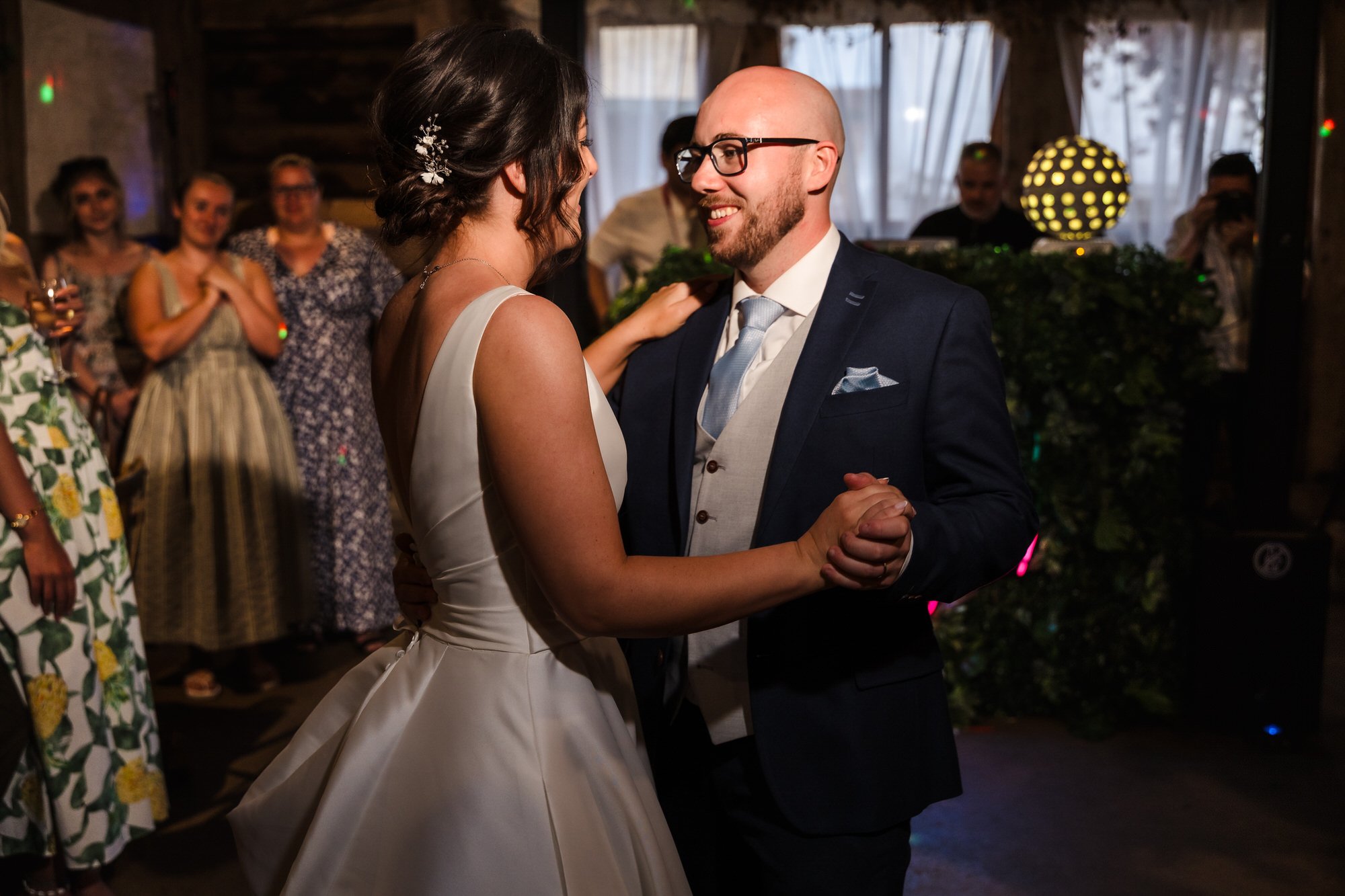 Bride and groom sharing their first dance inside The Fleece Inn's barn, evening reception photography in Worcestershire