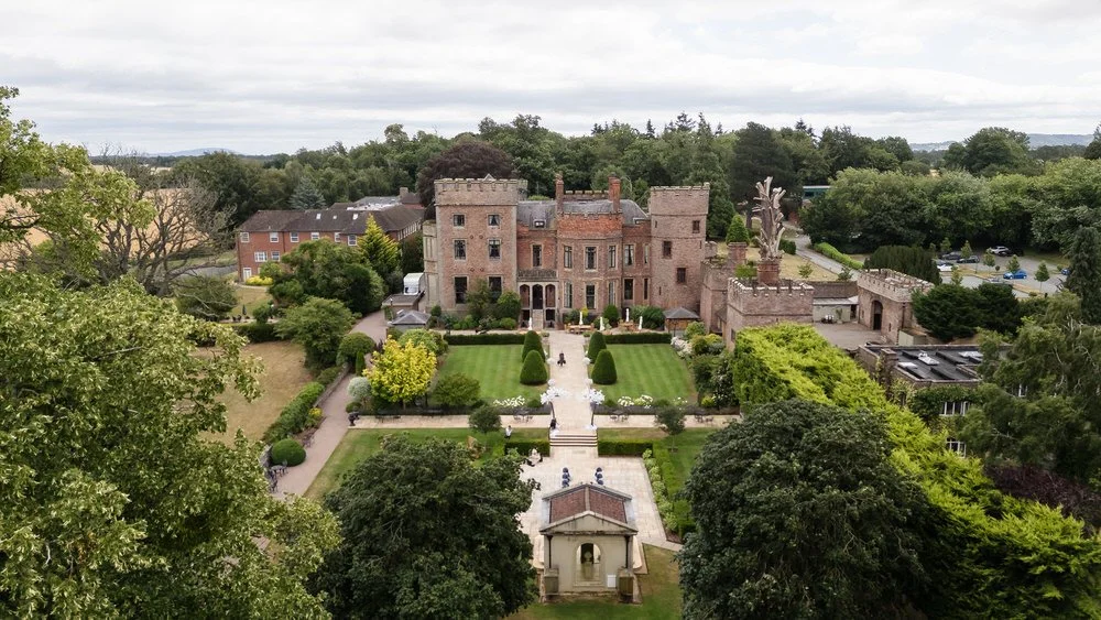 Aerial view of the wedding ceremony gardens at Rowton Castle, with the outdoor ceremony structure and castle behind