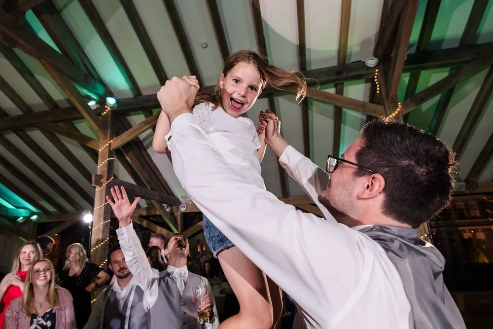 Joyful father-daughter moment at Bredenbury Court Oak Barn wedding reception in Herefordshire