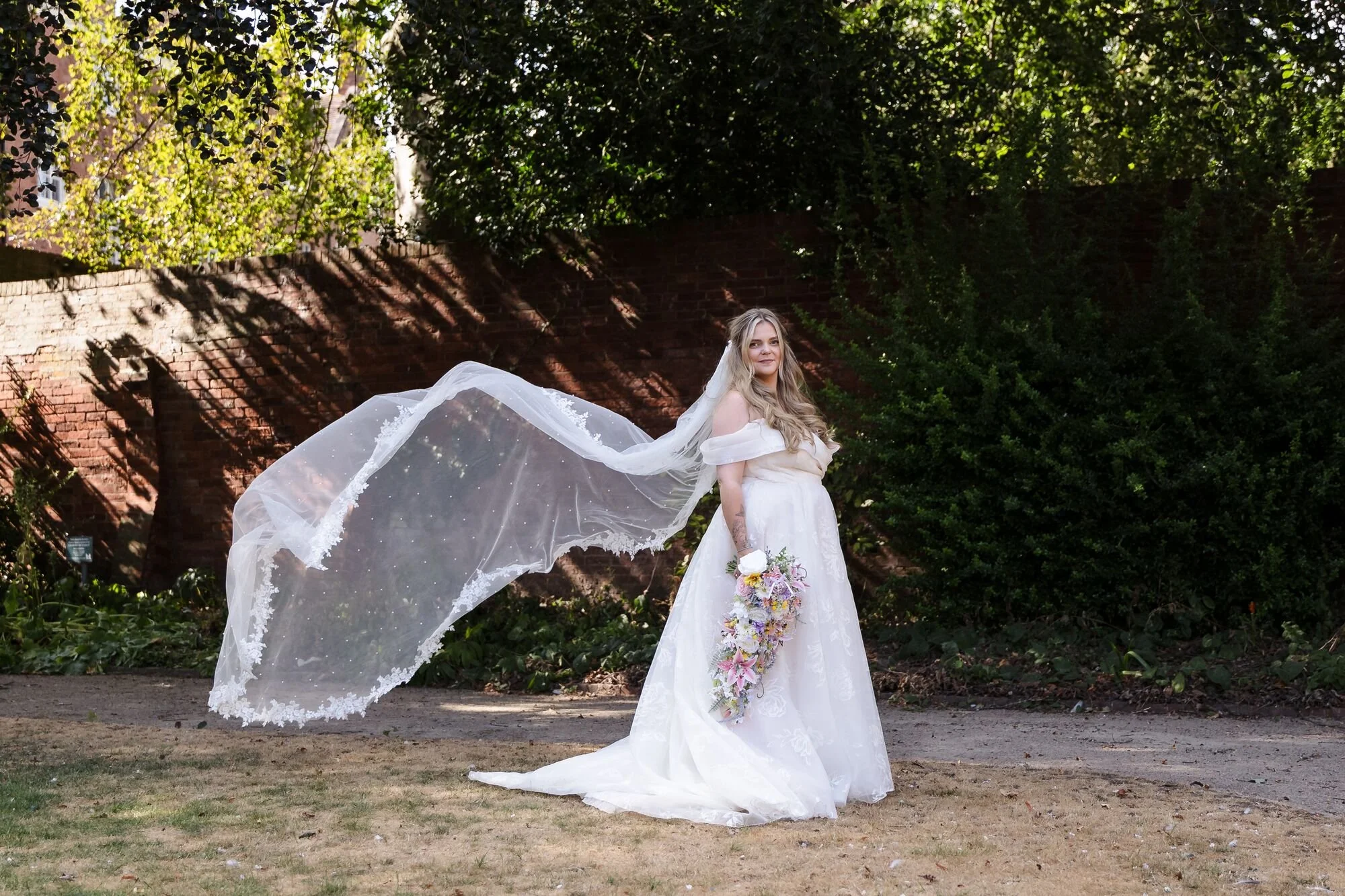 The bride's veil falling around her during her portraits in Lichfield, wedding photography by Once in a Lifetime Photography.