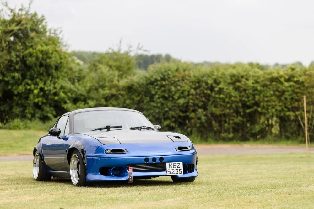 Stunning widebody modified Mazda MX-5 wedding car with custom body kit and wide wheels positioned in Worcestershire countryside.