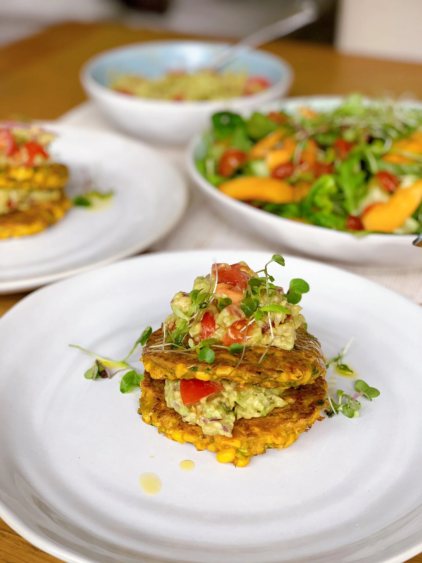 Nutrient dense corn and zucchini fritter recipe! Served with an avocado and tomato salsa.