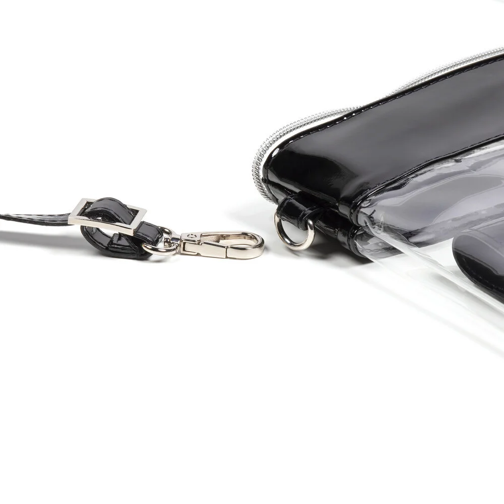 A detail of a clear purse with black trim showing the silver metal clip that connects the shoulder strap to the bag.