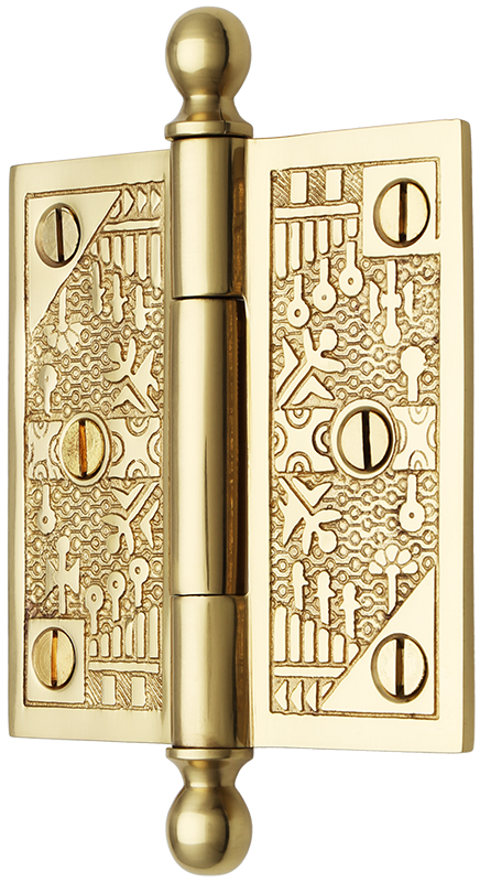 A shiny, gold, brass door hinge with decorative design and ball finials seen in three quarter view.
