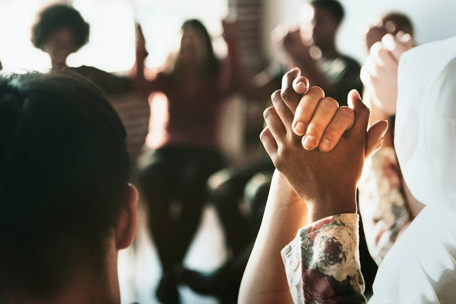 Shows a group of parents holding hands. Symbolizes how a postpartum support group in california will support new parents in their journey and transition to parenthood.