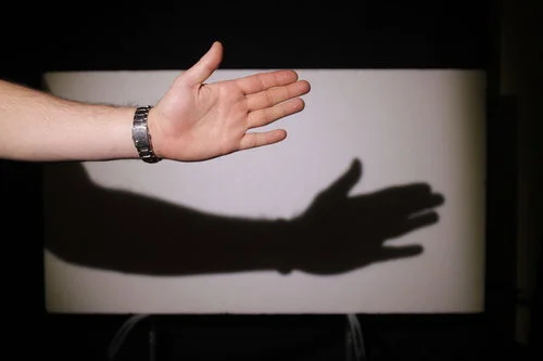 Shining an 800W 'redhead' fresnel without any diffusion to create a strong, well defined shadow (I used to be a hand model, you know). To make the shadow even more prominent I would need to increase the distance between my hand and the light.