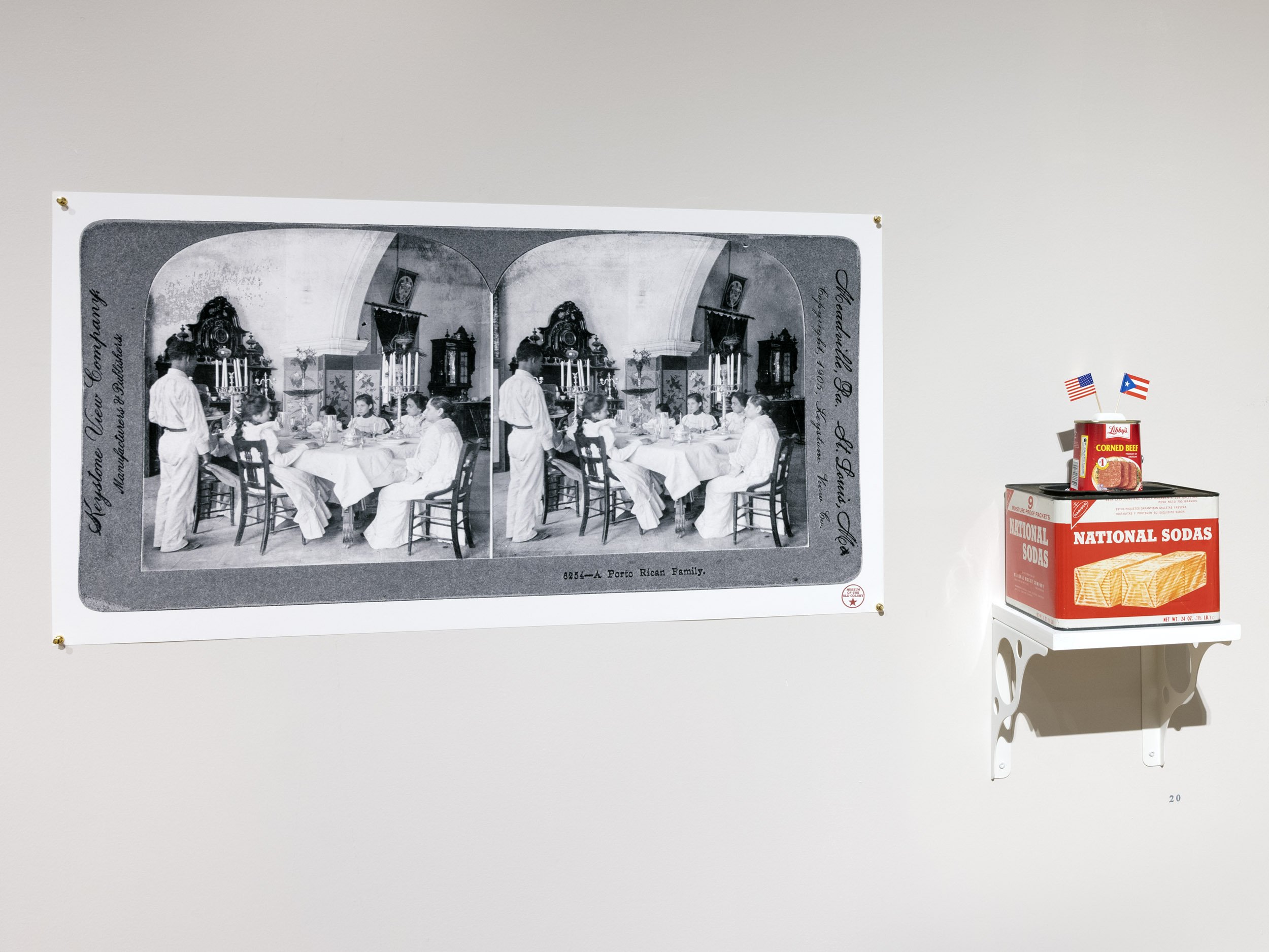  Installation view.  A Porto Rican Family . Keystone View Company, Meadville, PA, 1905 | 2021 and  Plum Pudding . Assemblage of found objects: Libby’s Corned Beef, Nabisco National Sodas, and miniature flags | 2021.  The Museum of the Old Colony , Du