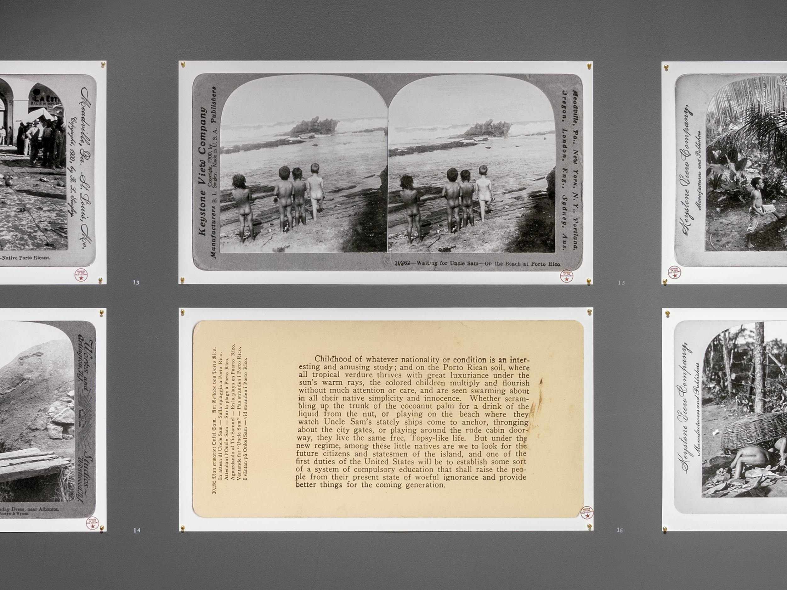  Installation view (cropped). Stereographs of Puerto Rican children; at center:  Waiting for Uncle Sam–On the Beach at Porto Rico  and caption. Photograph by B.L. Singley, Keystone View Company, Meadville, PA, 1900 | 2019.  The Museum of the Old Colo