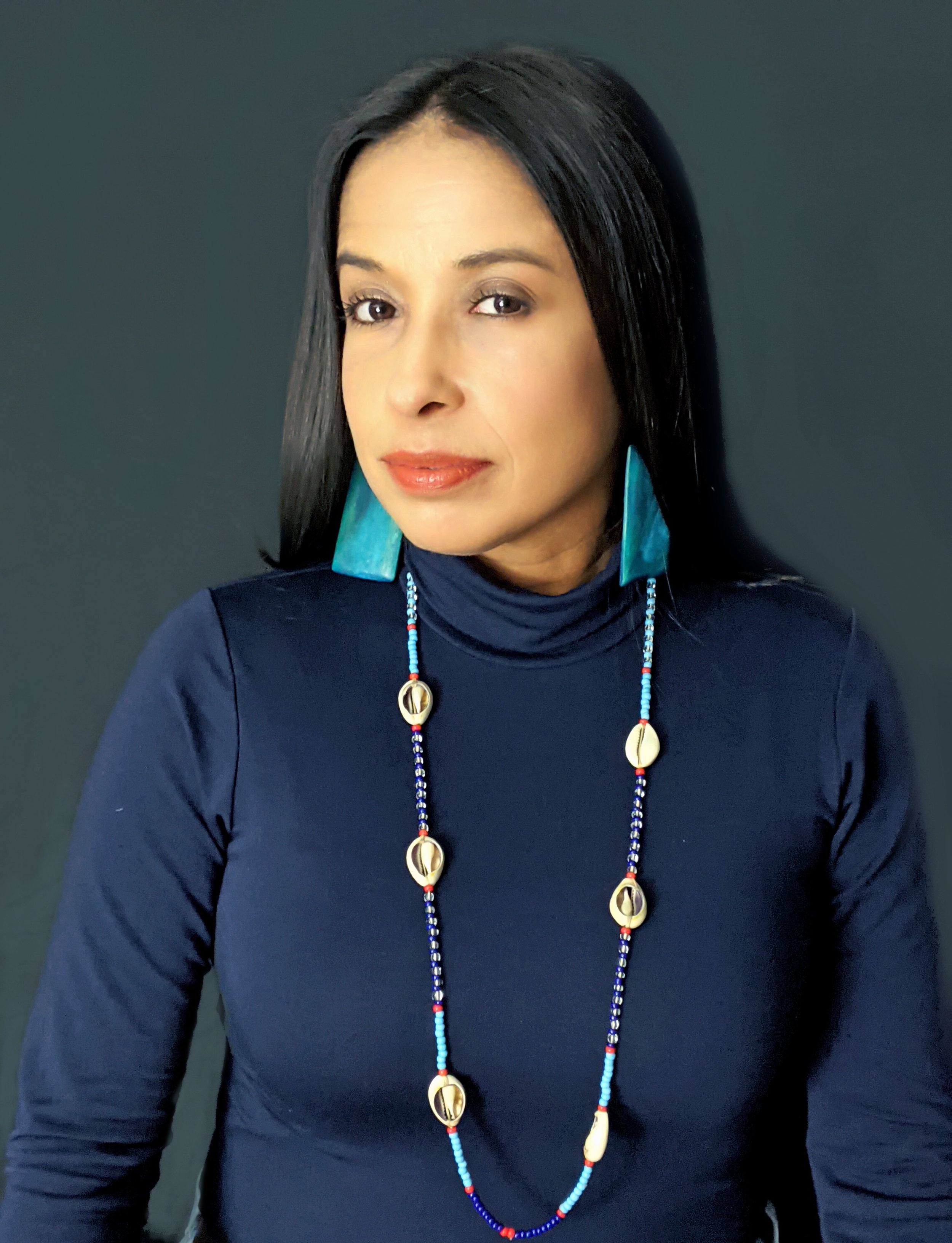 headshot of peggy robles alvarado in  a turtleneck and turquoise jewelry