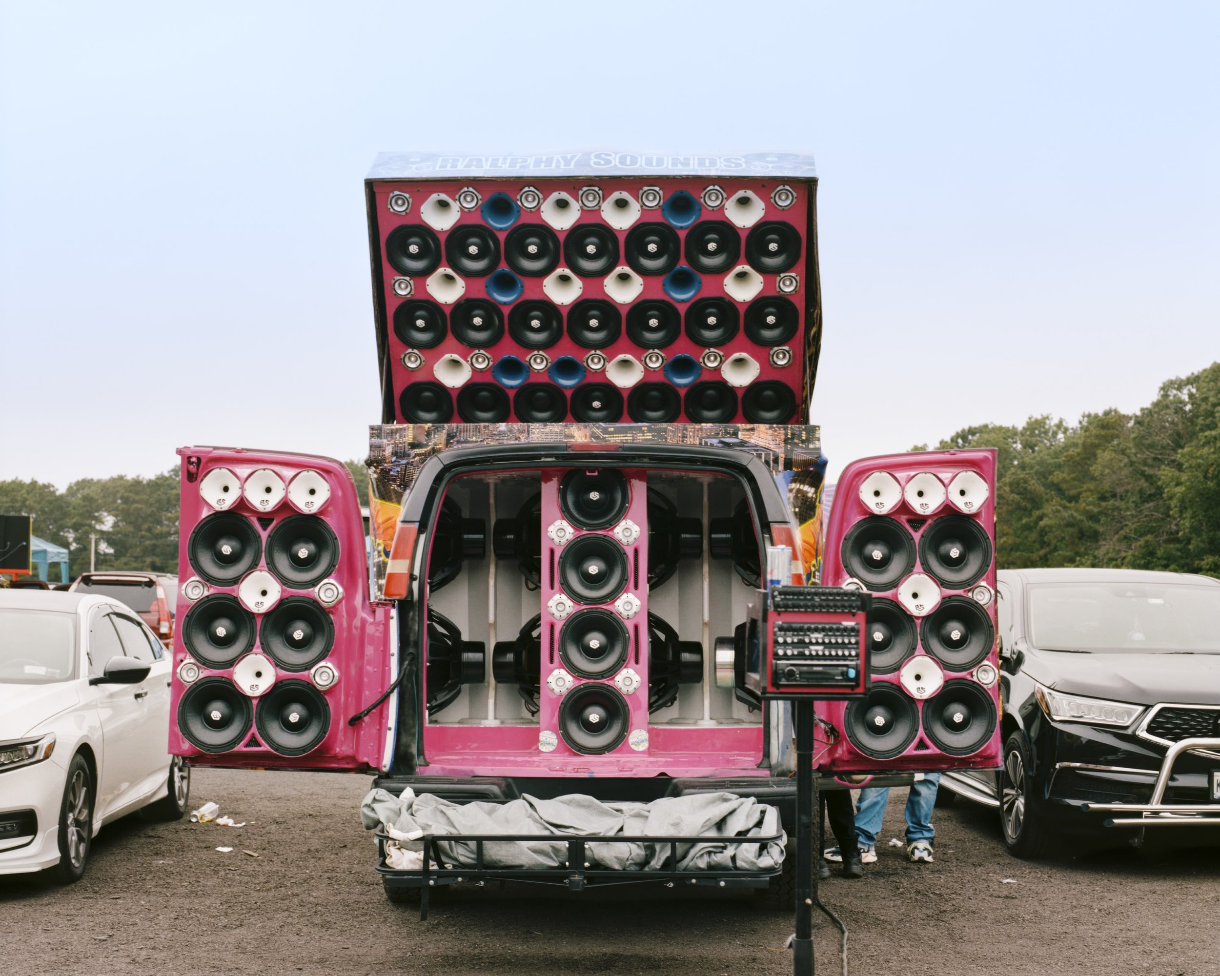 A van with speakers in the trunk, the trunk doors, and the roof