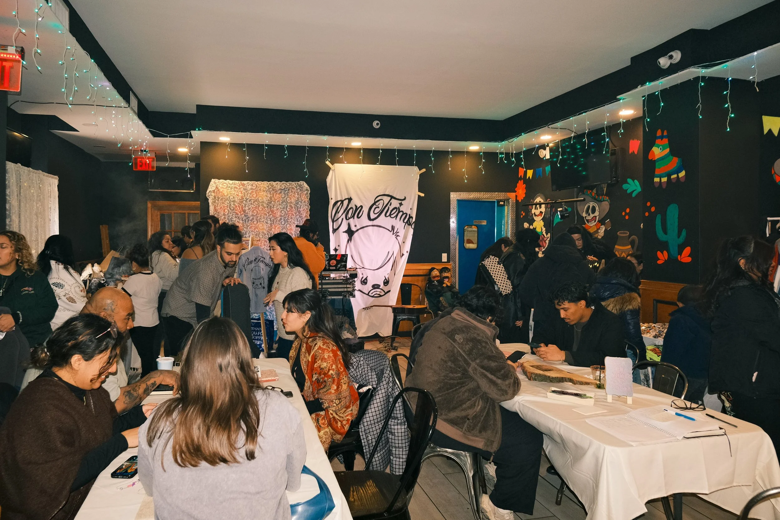 a group of people at different tables at a con tiempo event