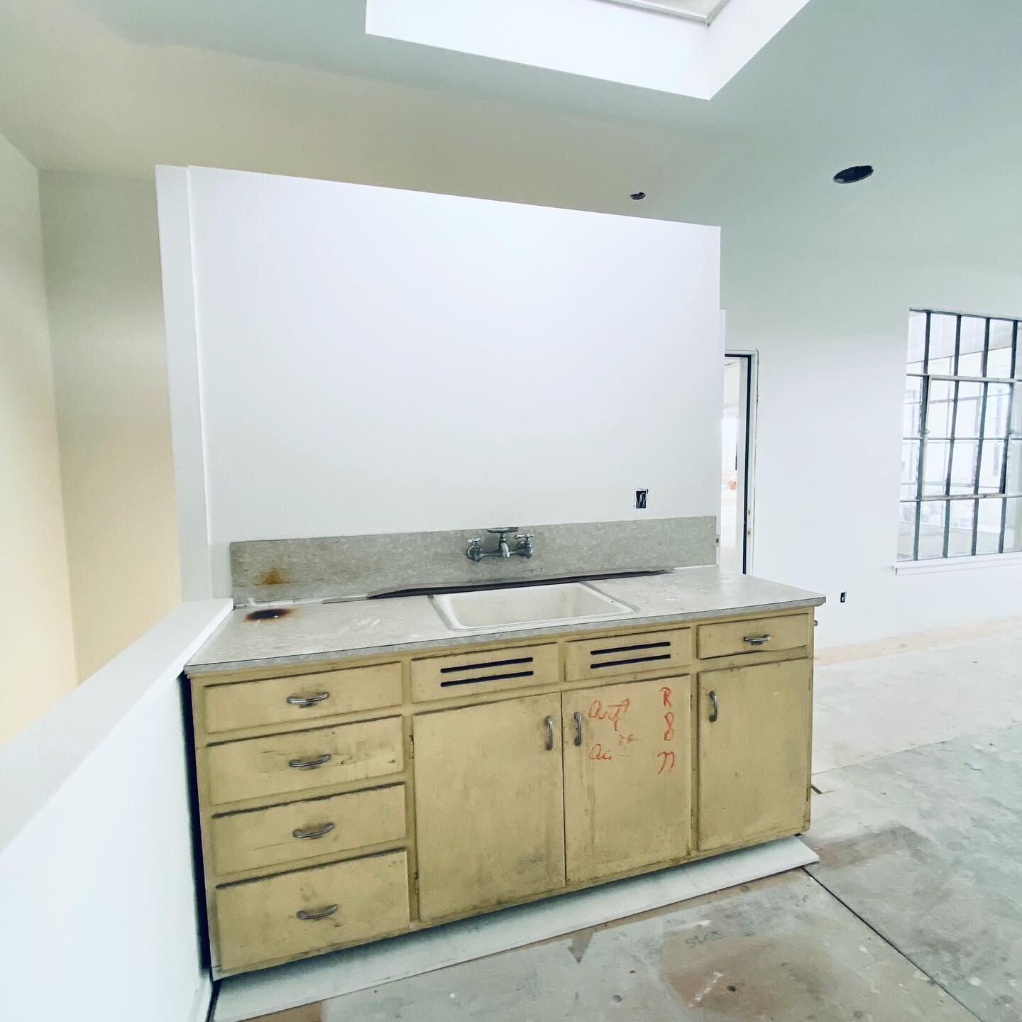 Space in flux: we're excited to refresh this office kitchenette with some key updates. Swipe to see the backsplash built up with tile and a salvaged wood shelf. Still to come: paint on the cabinets, wallpaper, new flooring, a deep clean, and of cours