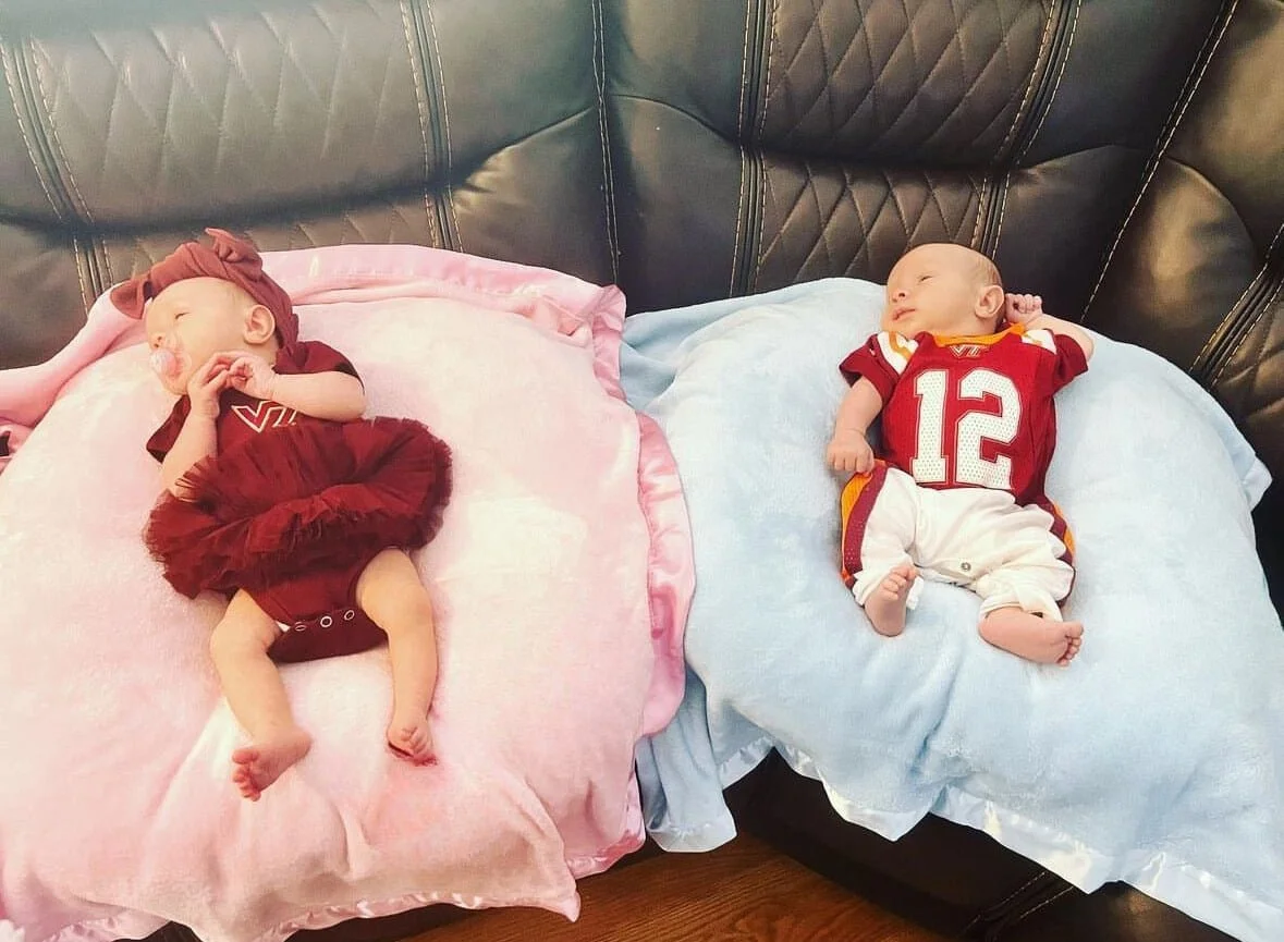 2 babies in Virginia Tech football outfits resting on pillows
