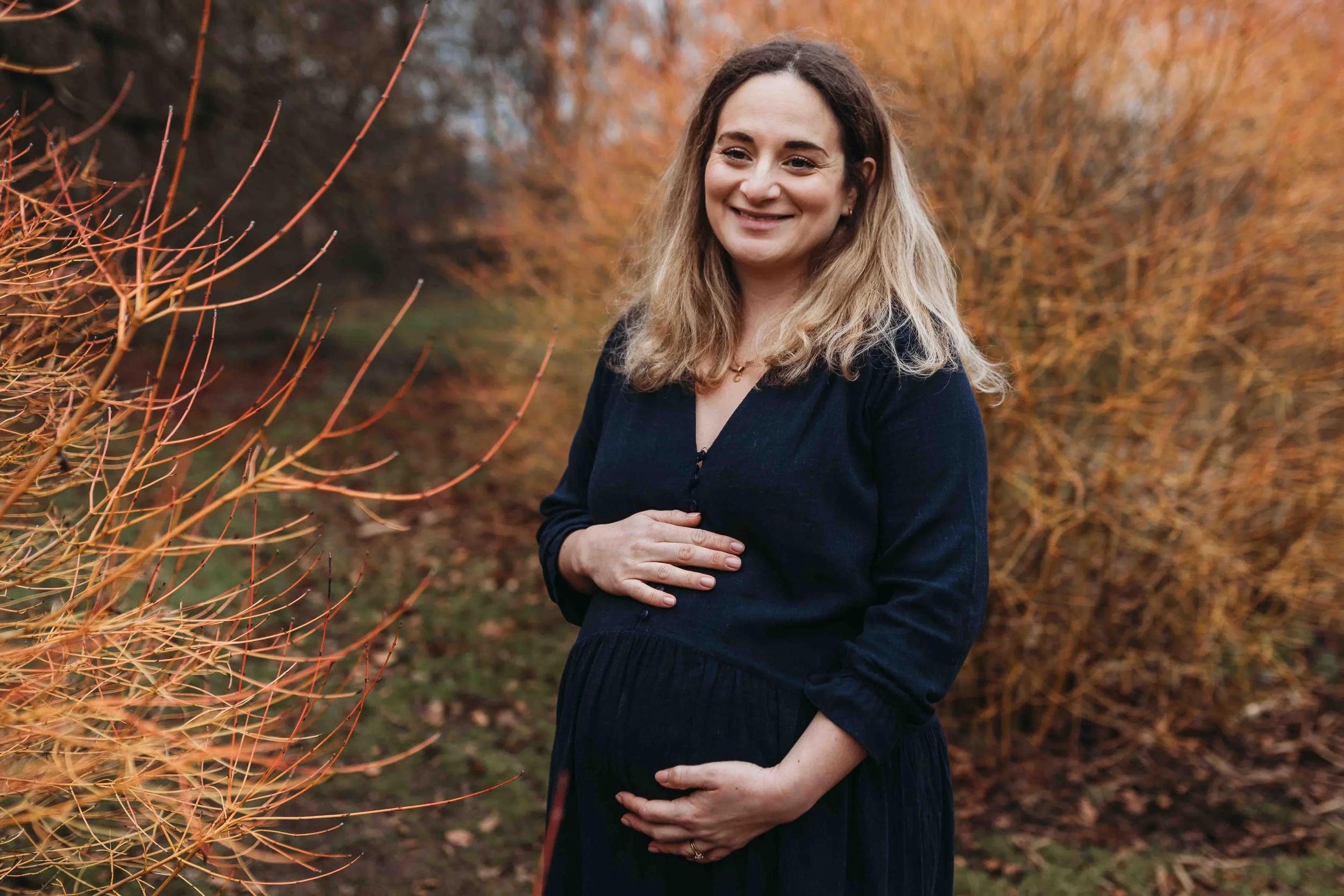 Pregnant mum smiling gently during a maternity session in Richmond park