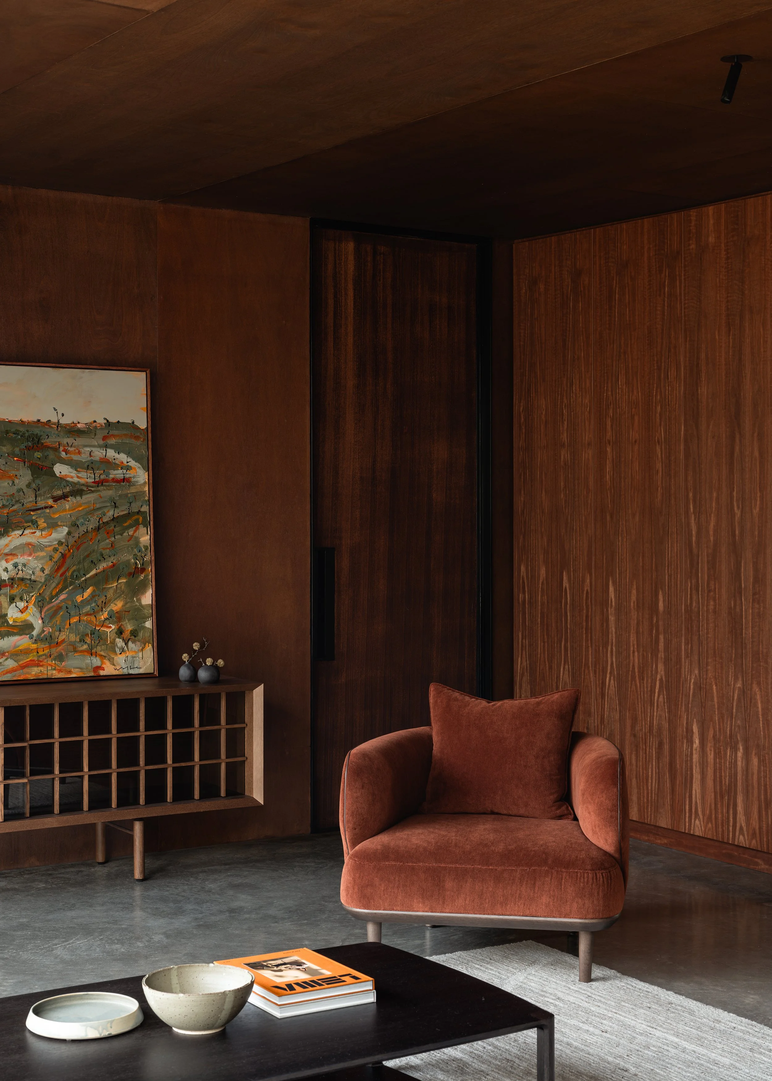 Cosh Living armchair and low cabinet set against dark timber walls in the living room at Matchbox.