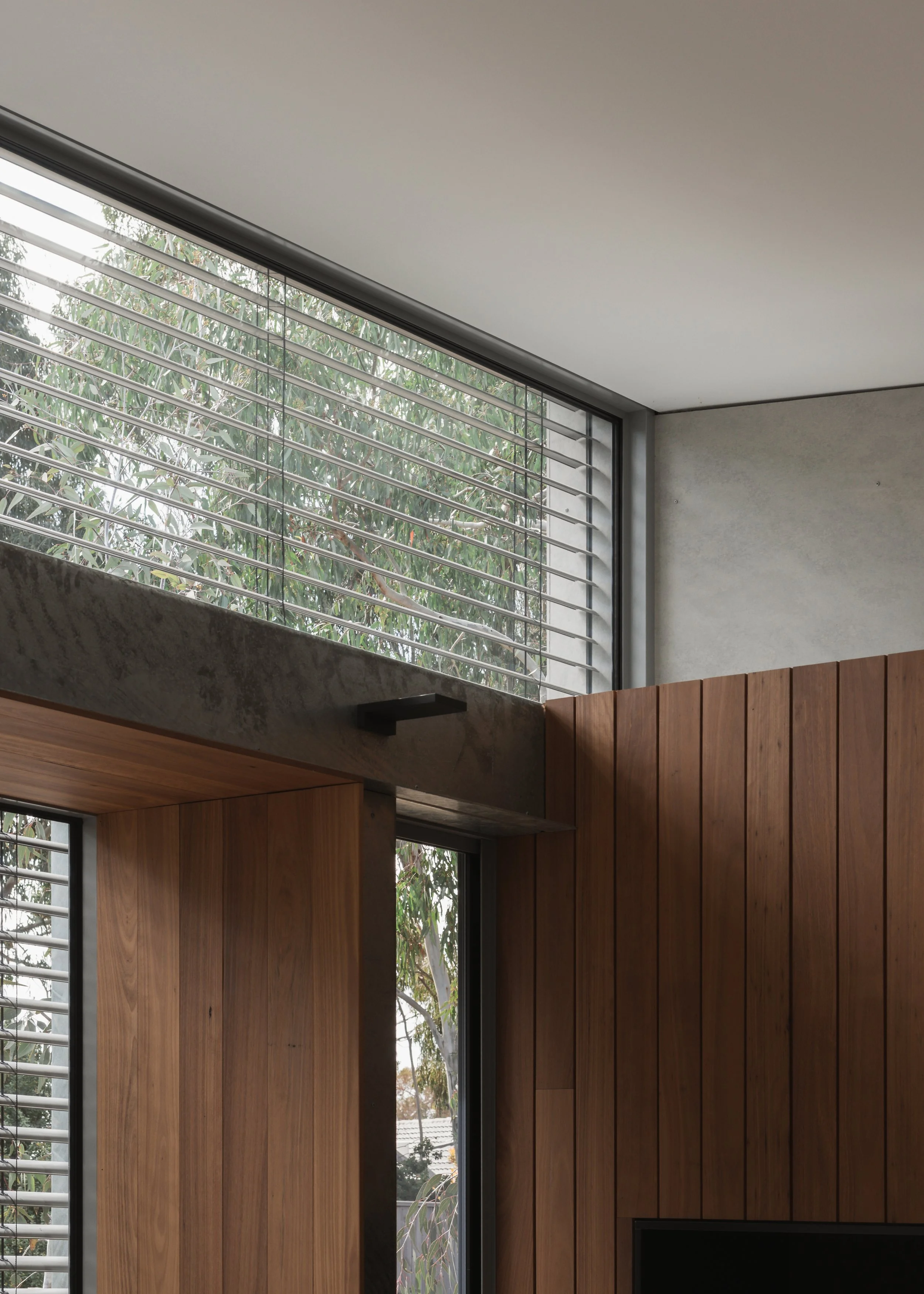 Clerestory window beneath a sloping white ceiling at Forest Road House, with external blinds from Shade Factor, exposed steel and timber lining.