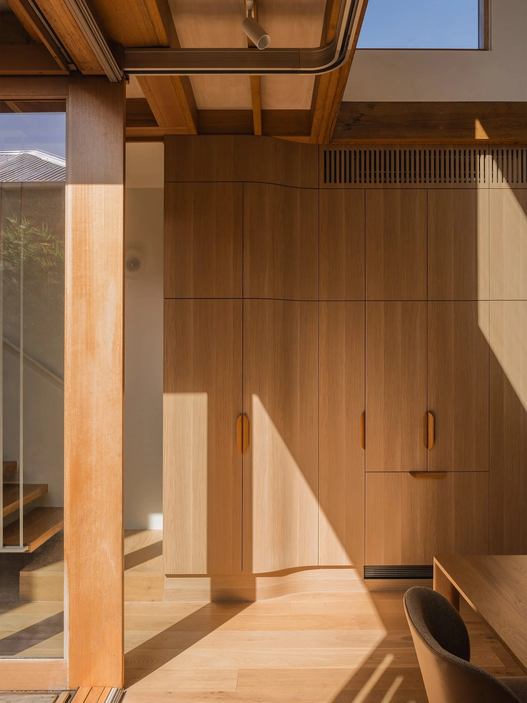 Northern sunlight falling across timber joinery and the open stair beside the internal courtyard at Little O’Grady.