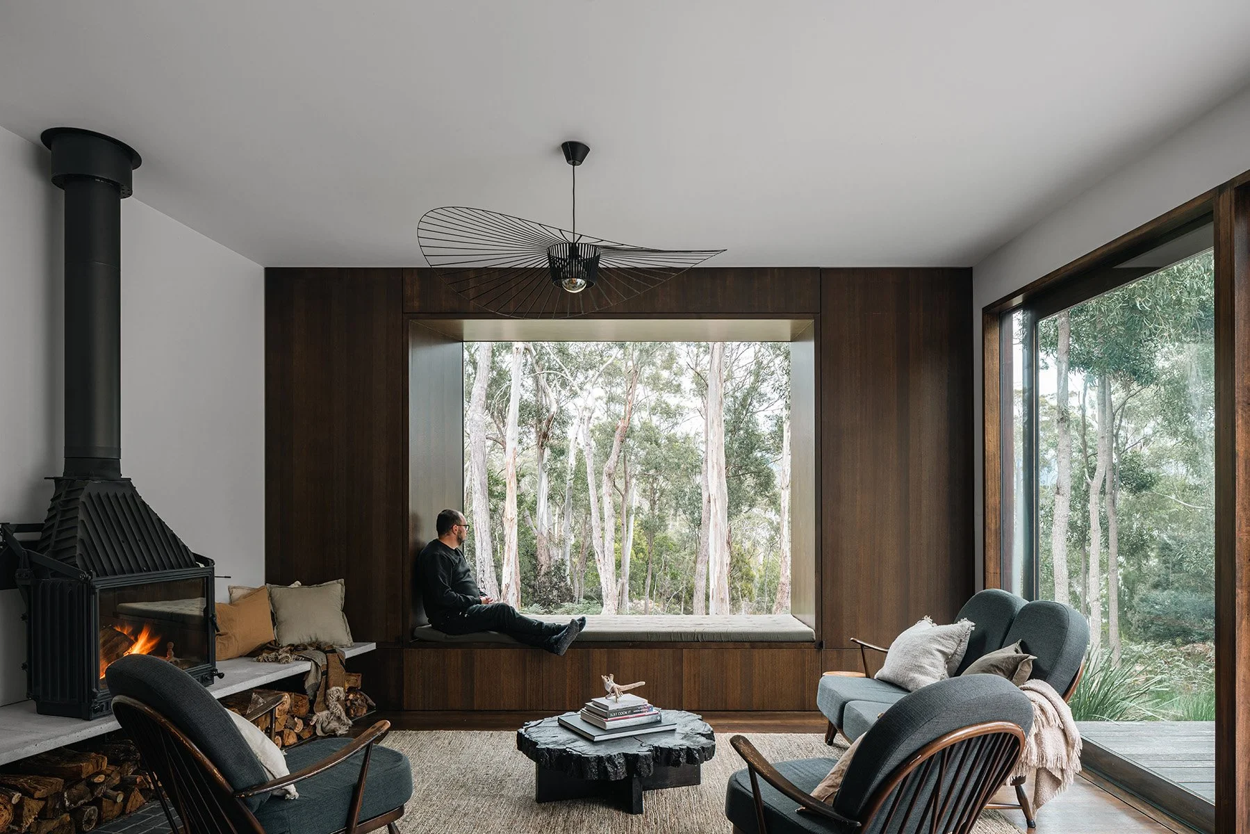Built-in window seat framing the white-gum forest at Killora Bay, Lara Maeseele’s Bruny Island retreat.