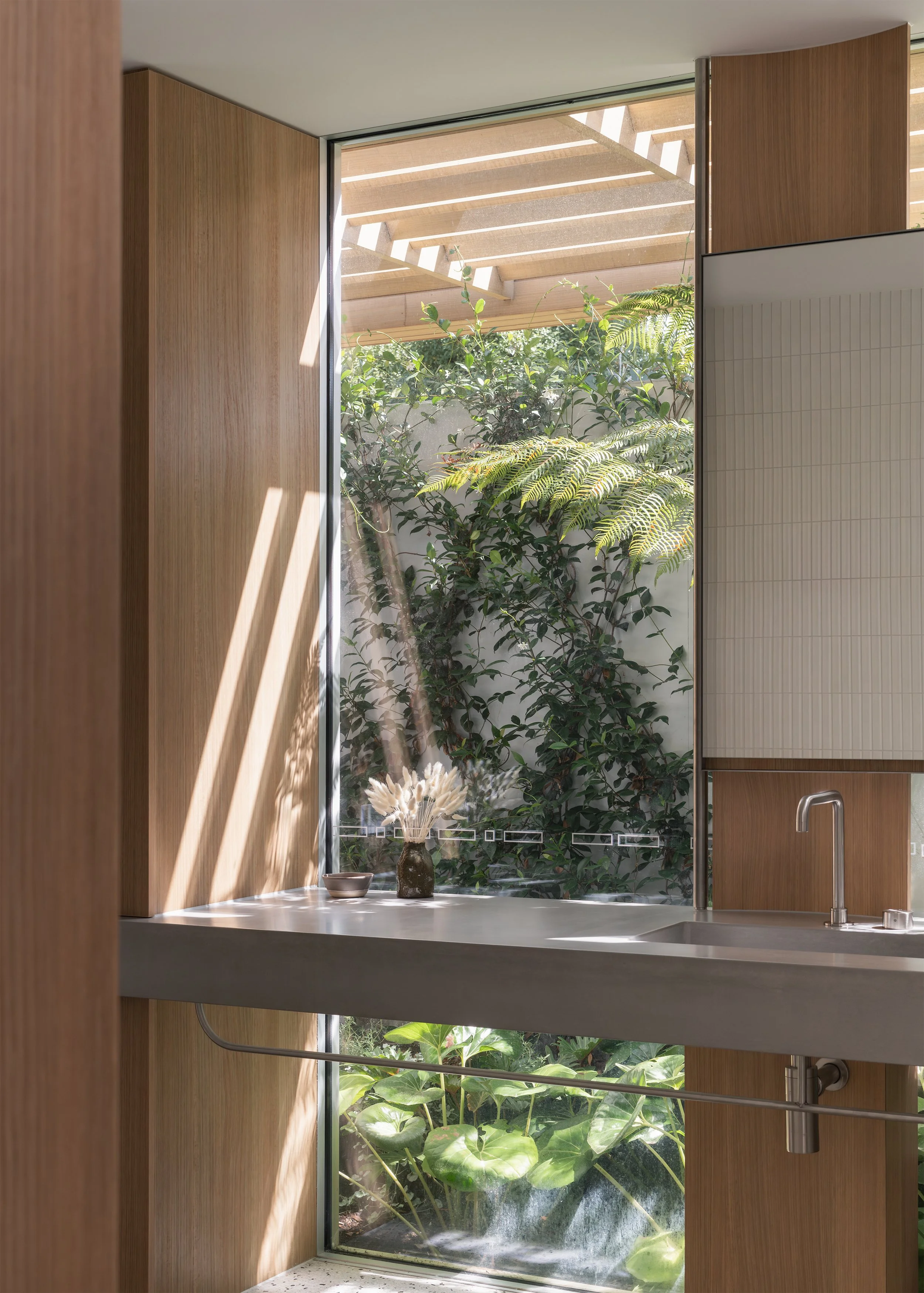 Concrete bathroom vanity, timber joinery and private garden outlook within this contemporary Australian home in Mornington.