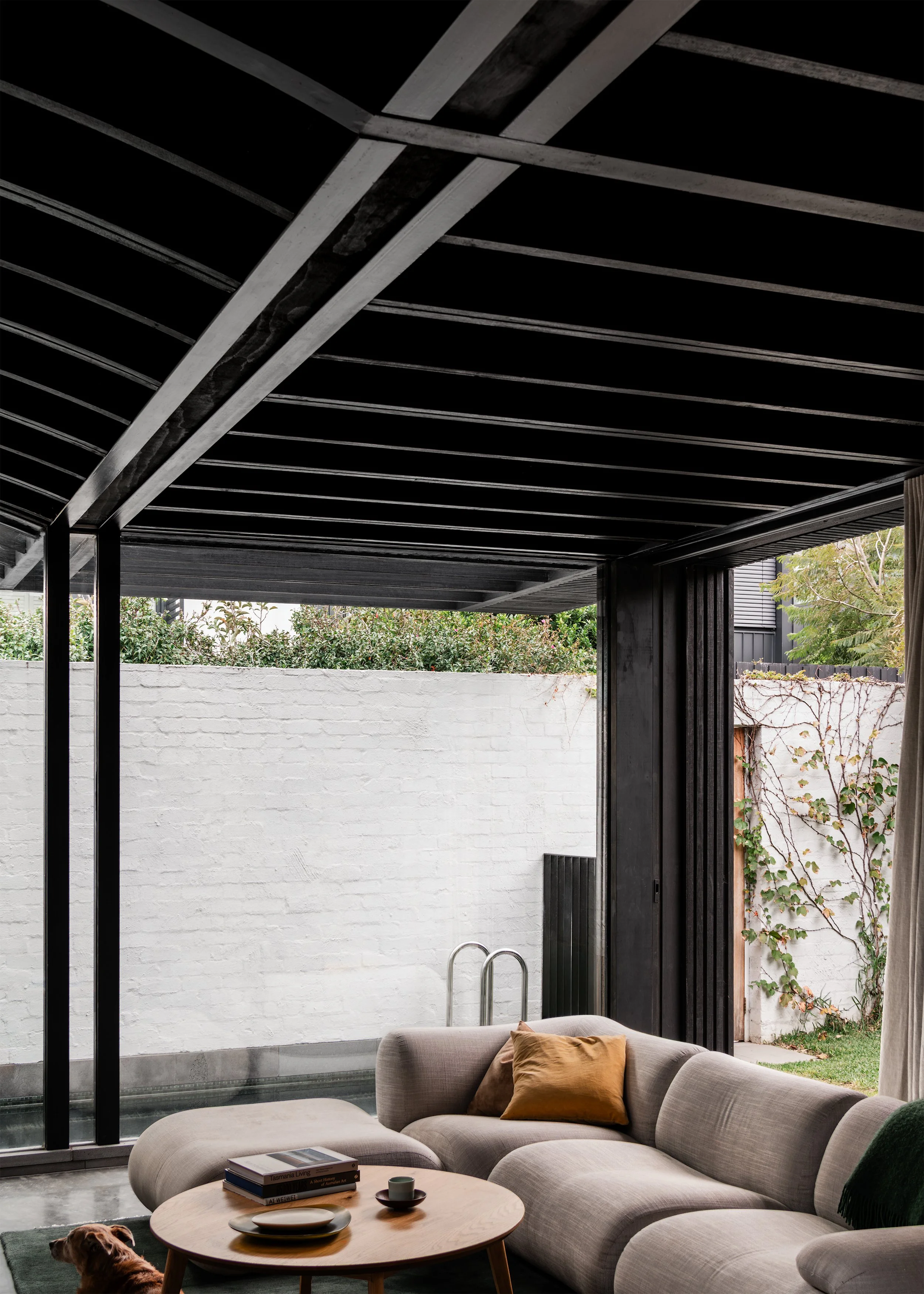 Living room beside the pool and high masonry garden wall at Borrowed Garden House.