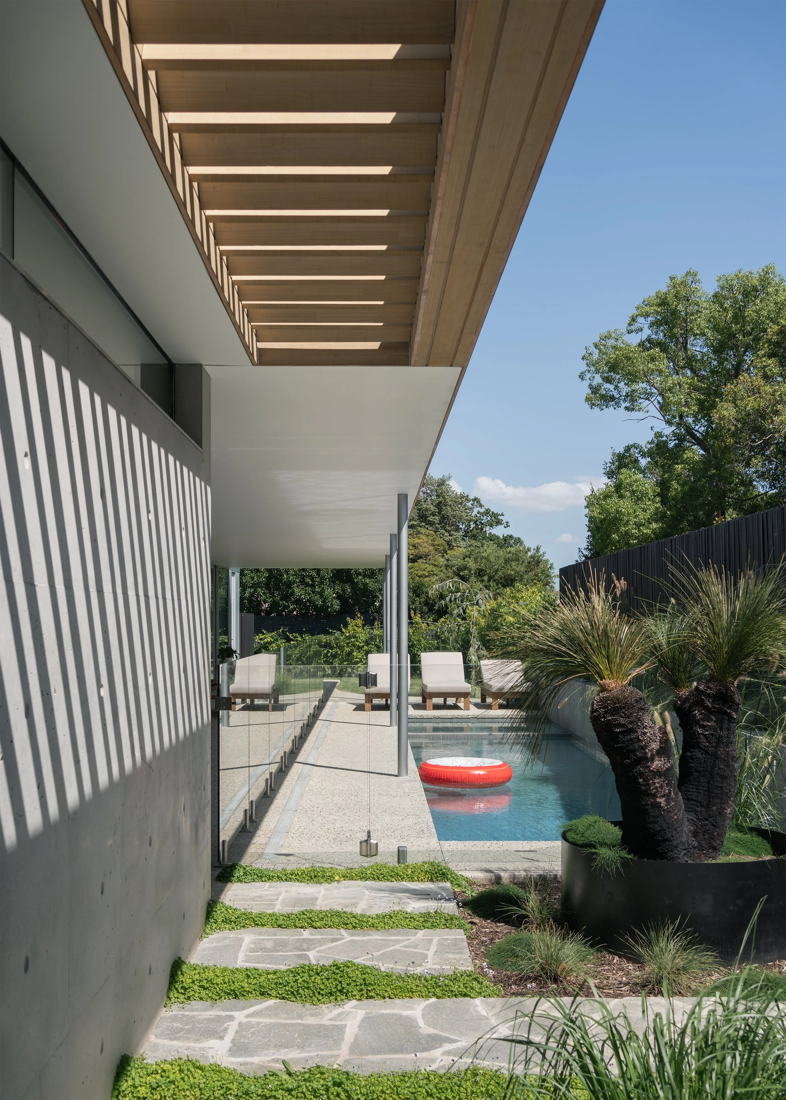 Swimming pool and landscaped garden beneath the deep timber roof and pergola of this contemporary Mornington house.
