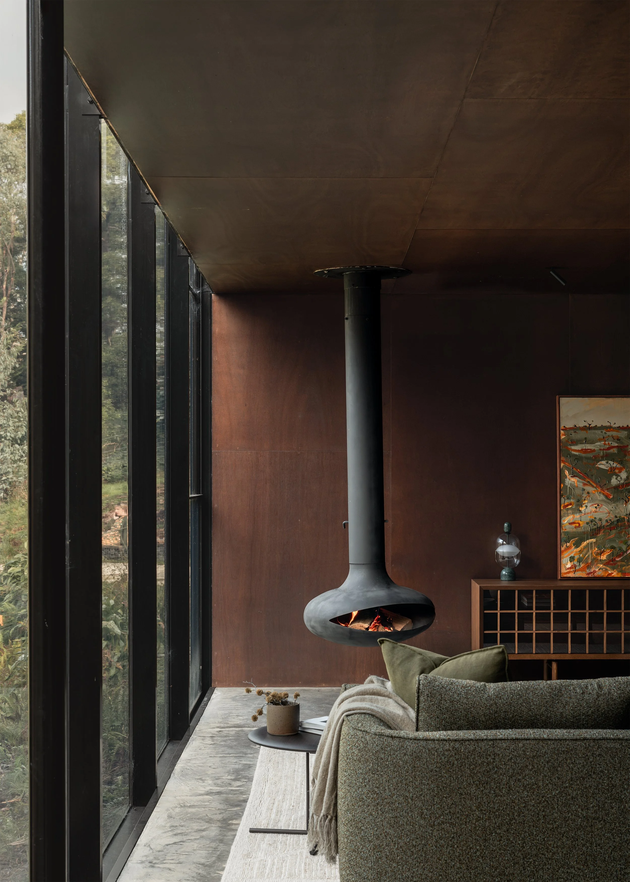 Living room Cosh Living sofa beside full-height glazing and a suspended fireplace at Matchbox by Vincent Jarvis Studio.