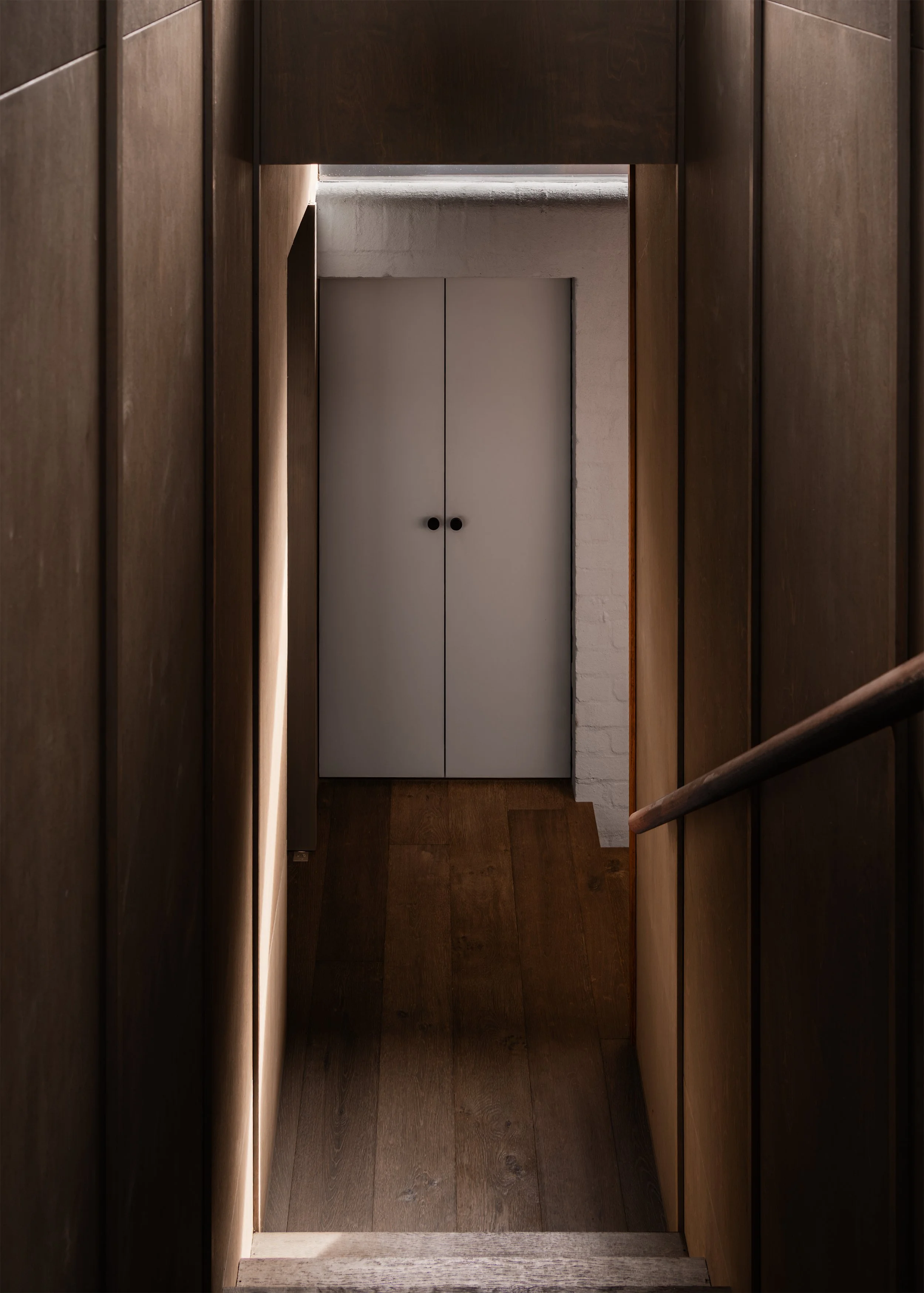 Plywood-lined stair and landing marking the transition between the Victorian house and new upper level.