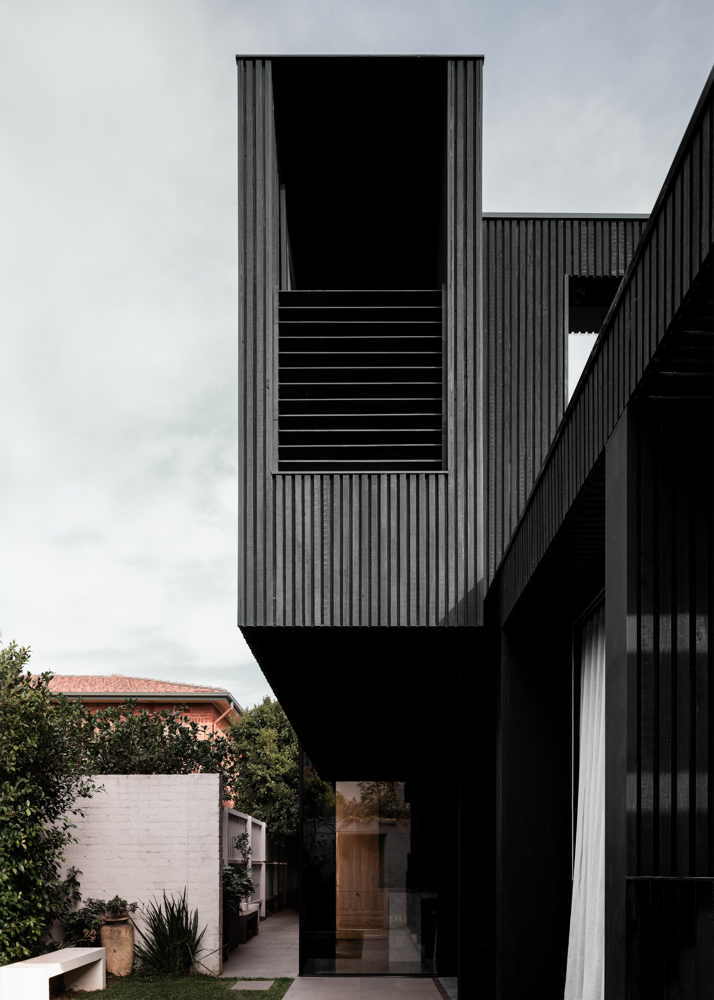 Tall black-clad upper volume overlooking the garden in Topology Studio’s Albert Park alteration and addition.