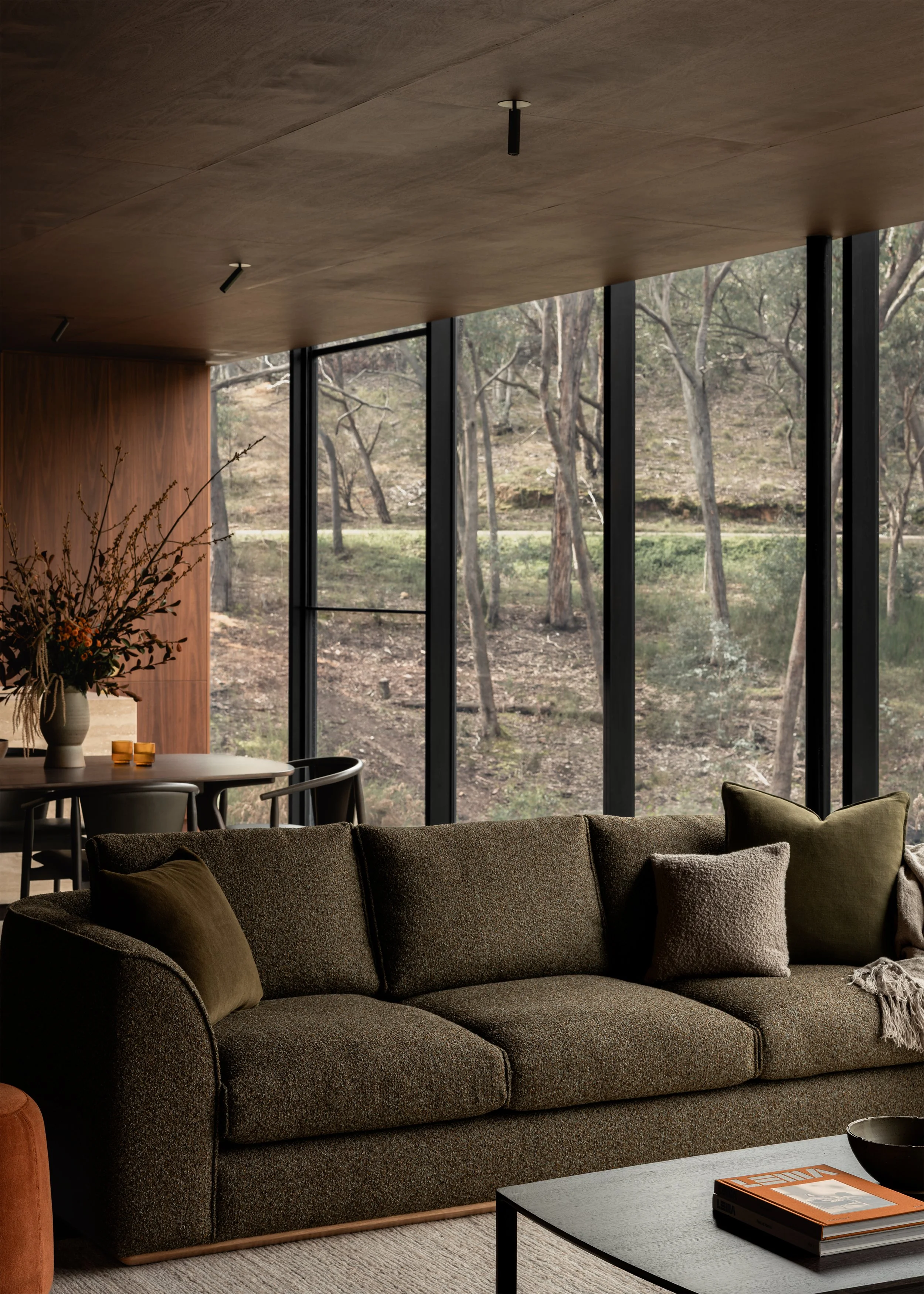 Living room sofa from Kett Furniture beside full-height glazing overlooking the surrounding bushland at Matchbox.