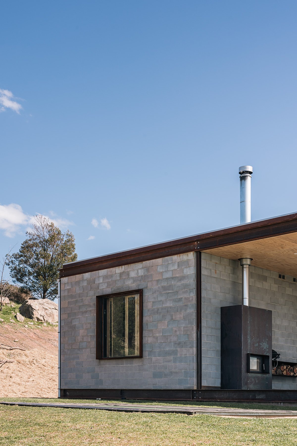 Concrete block rear volume and external fireplace express the robust material palette of Robbie J Walker’s Mansfield House.