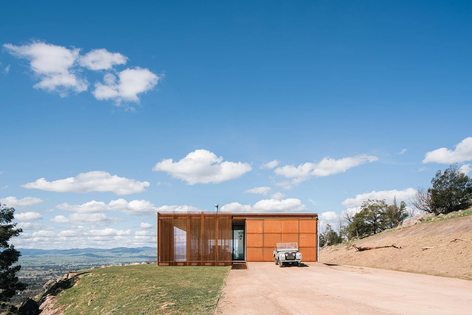 Weathered-steel exterior of Mansfield House by Robbie J Walker, an Australian off-grid home on a rocky hill in Mansfield, Victoria.