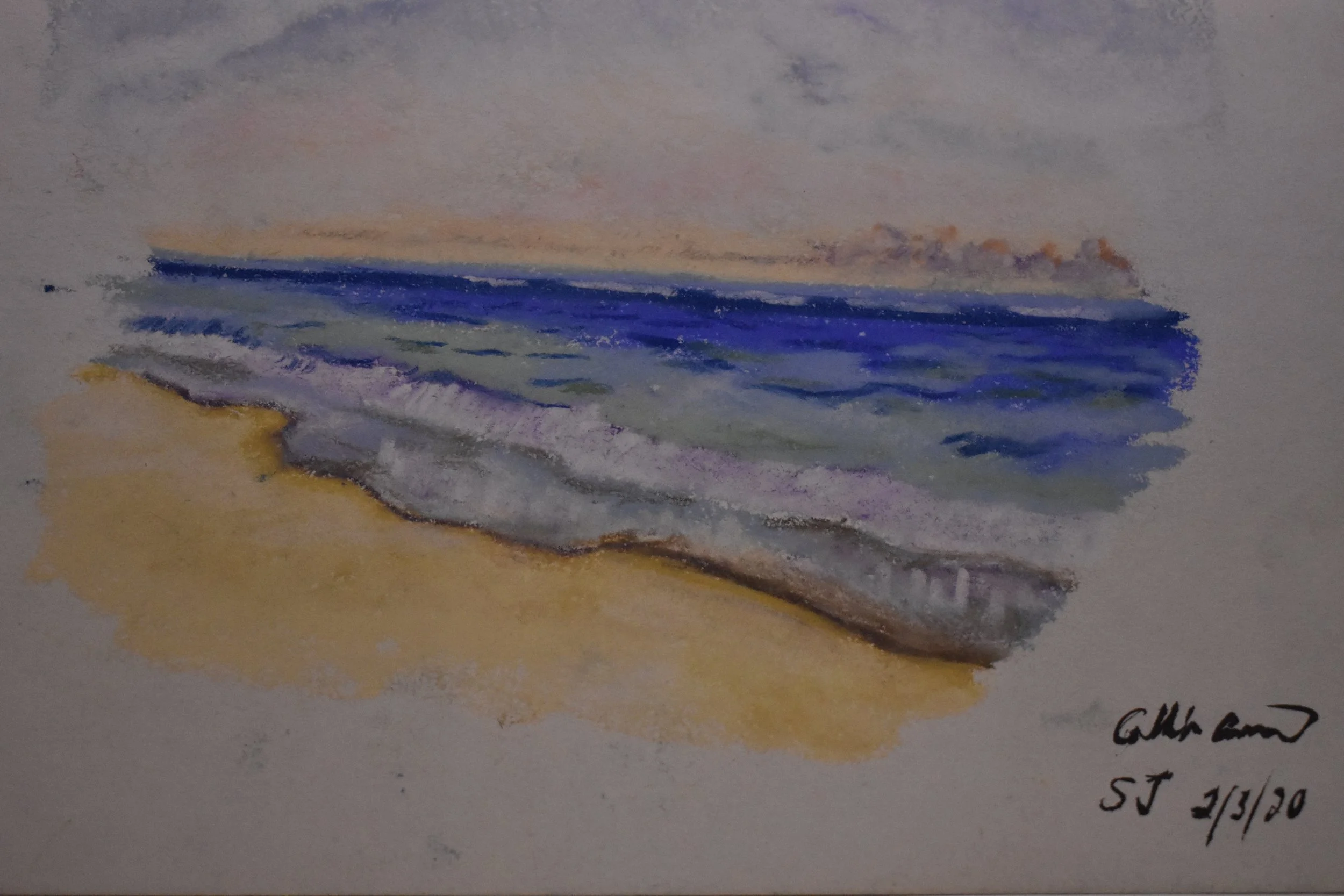 Watercolor painting of a sandy beach with ocean waves and sky in the background. The water is depicted in shades of blue and purple, with the sand in light yellow. The sky shows pastel hues, suggesting a sunset or sunrise. The artist's signature, dat