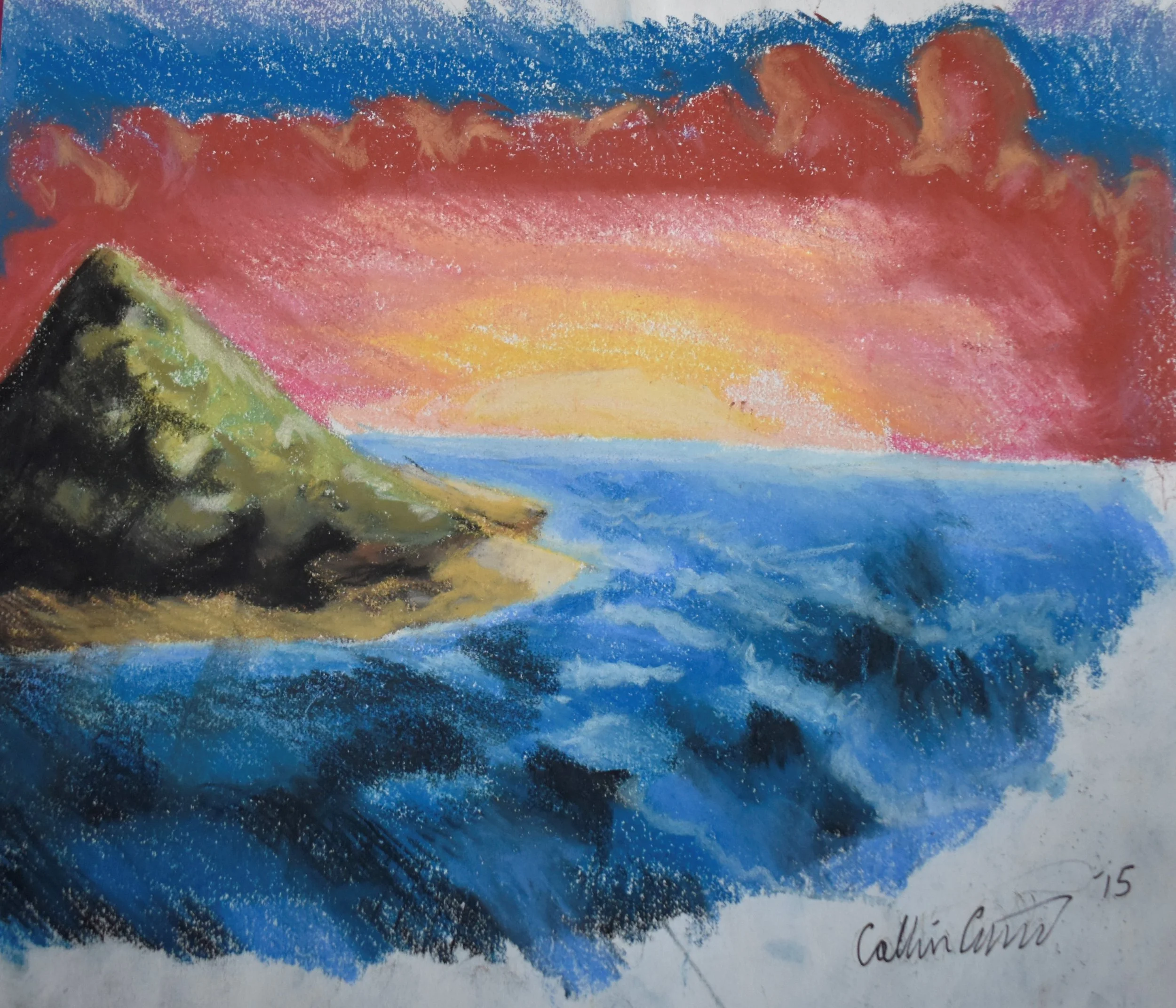 Pastel or crayon landscape painting of a coastline at sunset or sunrise with a blue ocean, green and black rocky cliff on the left, and a colorful sky with pink, orange, and yellow hues, signed by Callin Commt in 2015.