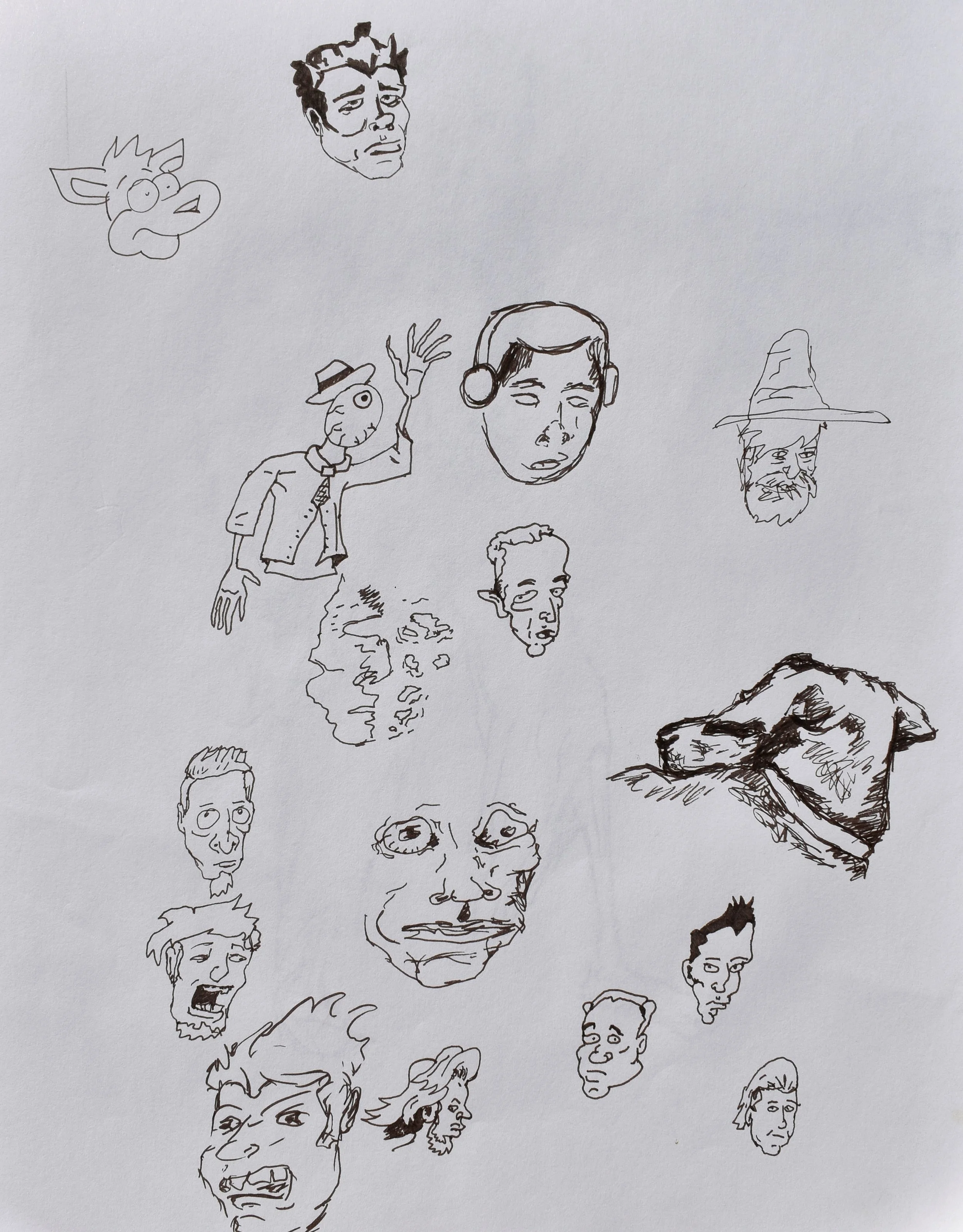 Collection of various hand-drawn cartoon and comic-style faces and characters on a sheet of paper, including a dog, a person with headphones, a wizard, and several other expressive faces.