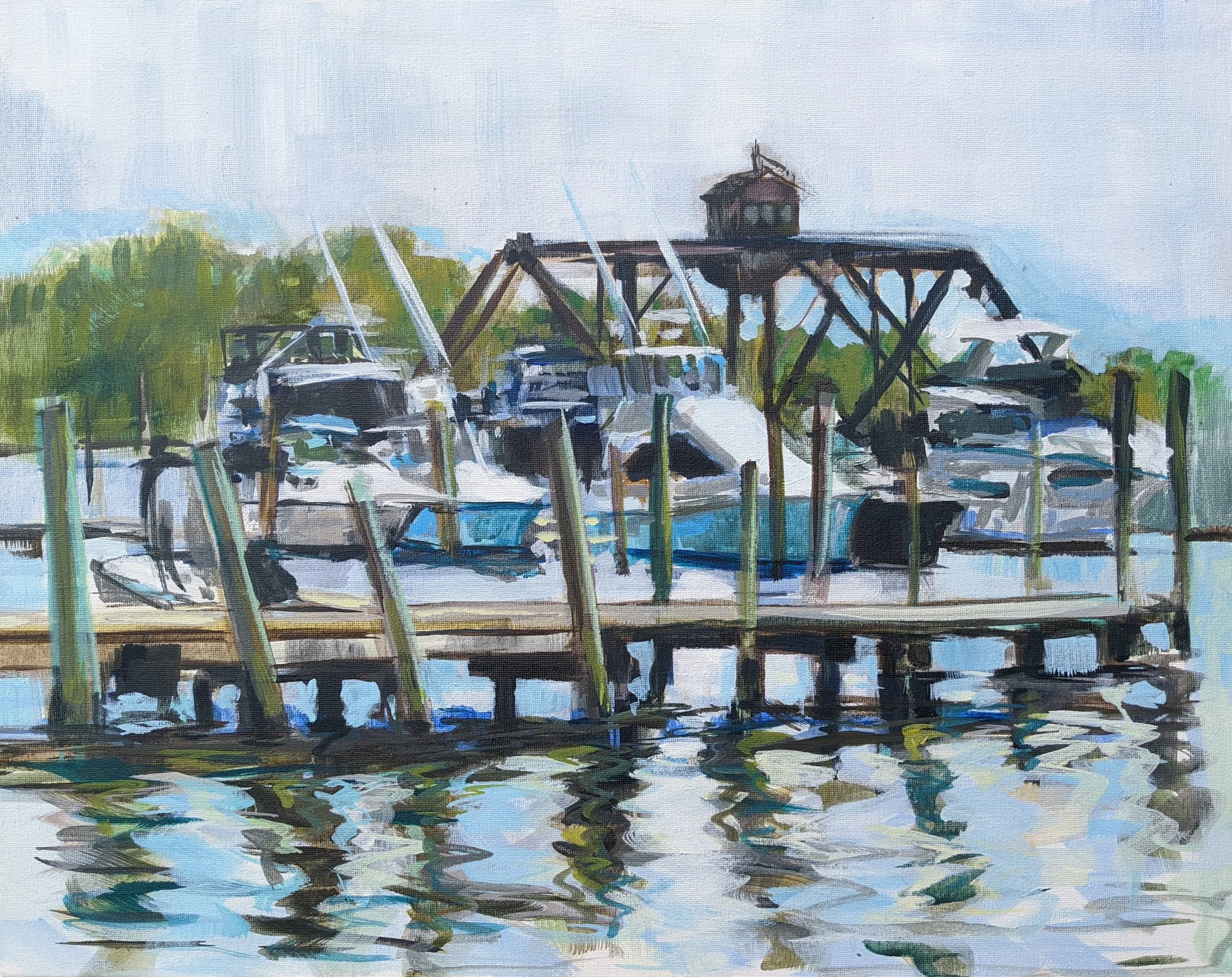 Watercolor painting of a marina with boats docked at a wooden pier, with a small lighthouse on a tower in the background and trees along the shoreline.