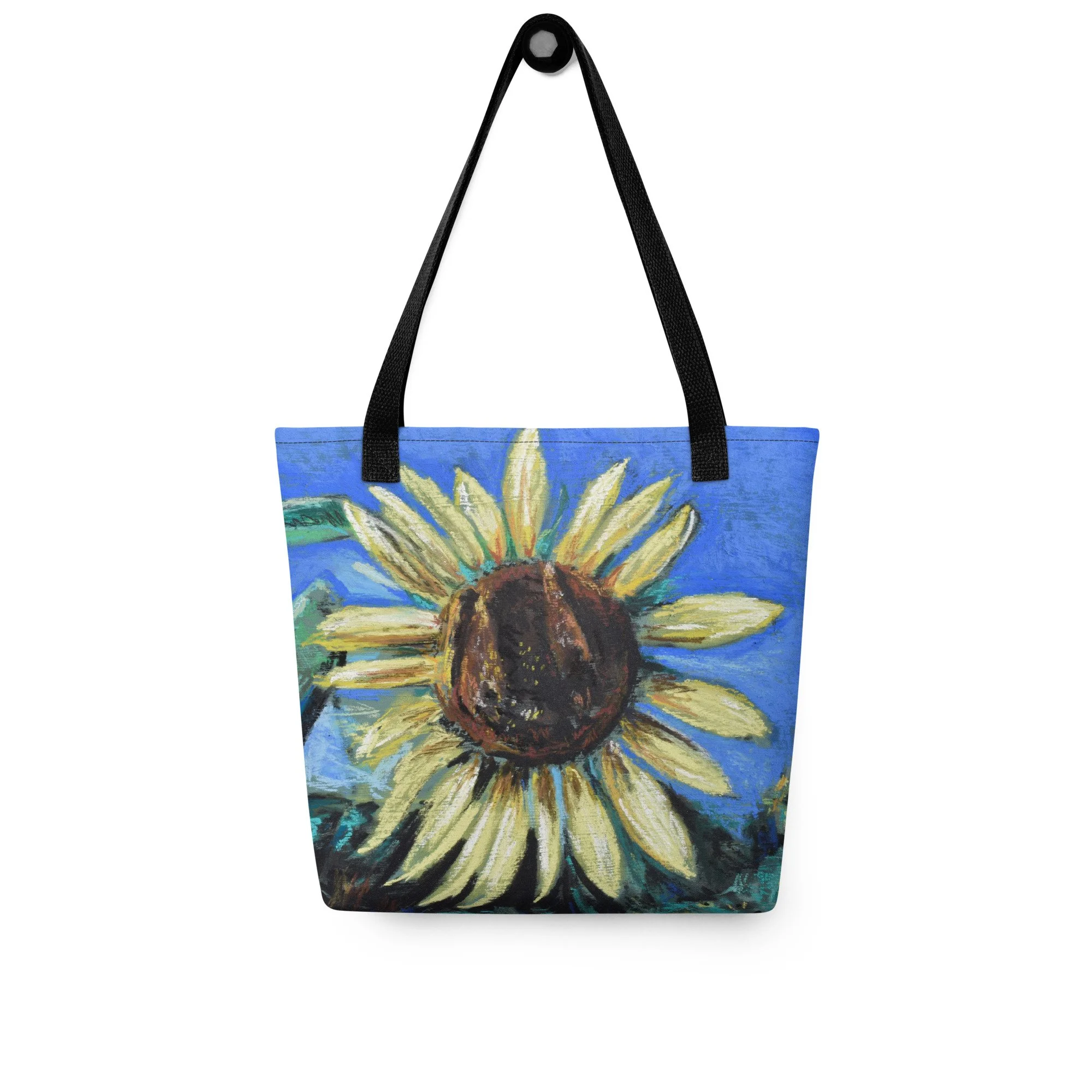 Tote bag with a painted sunflower design on a blue background and black straps.