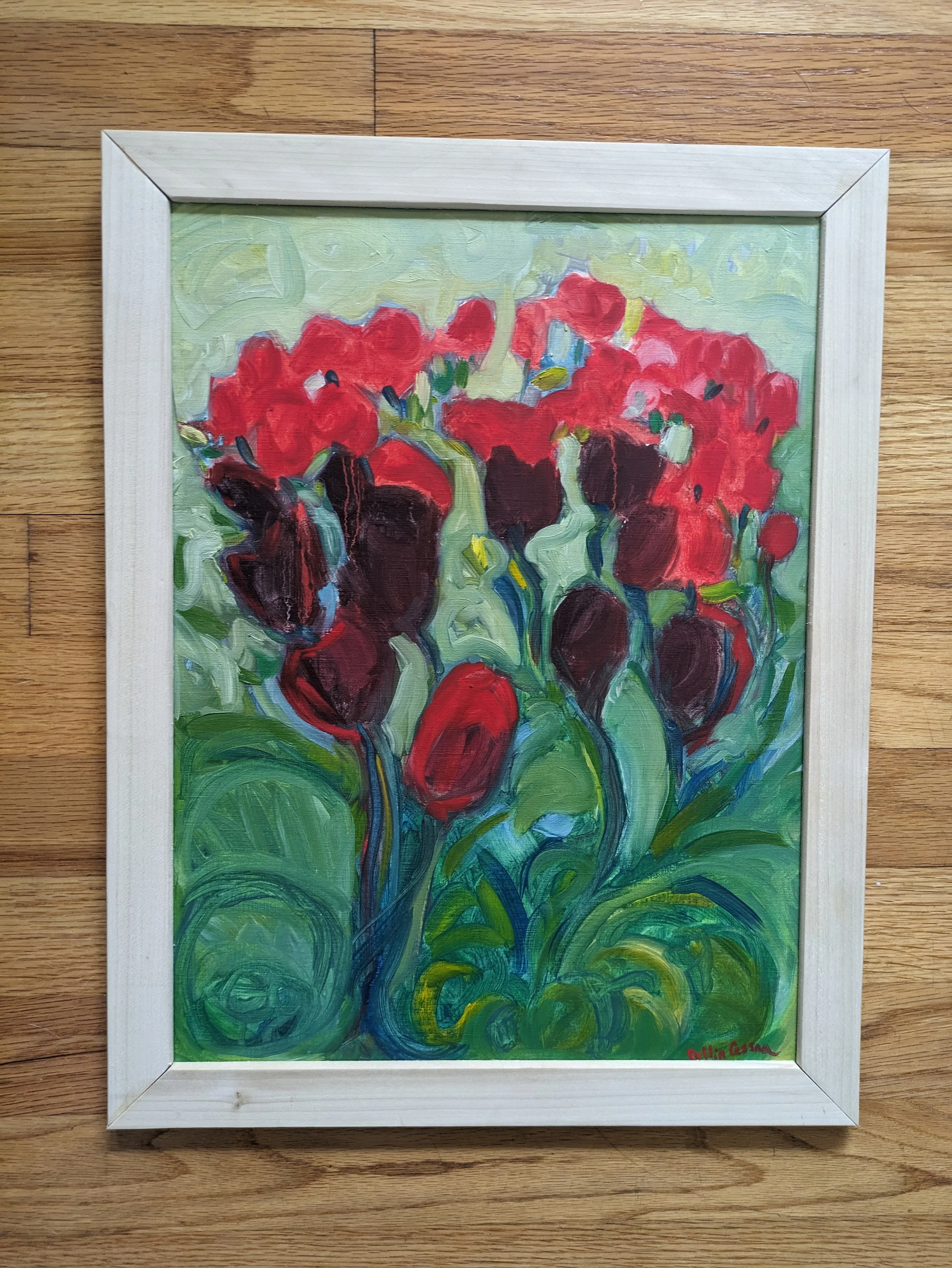 A framed painting of a bouquet of red and dark purple flowers with green leaves, painted in an Impressionist style.