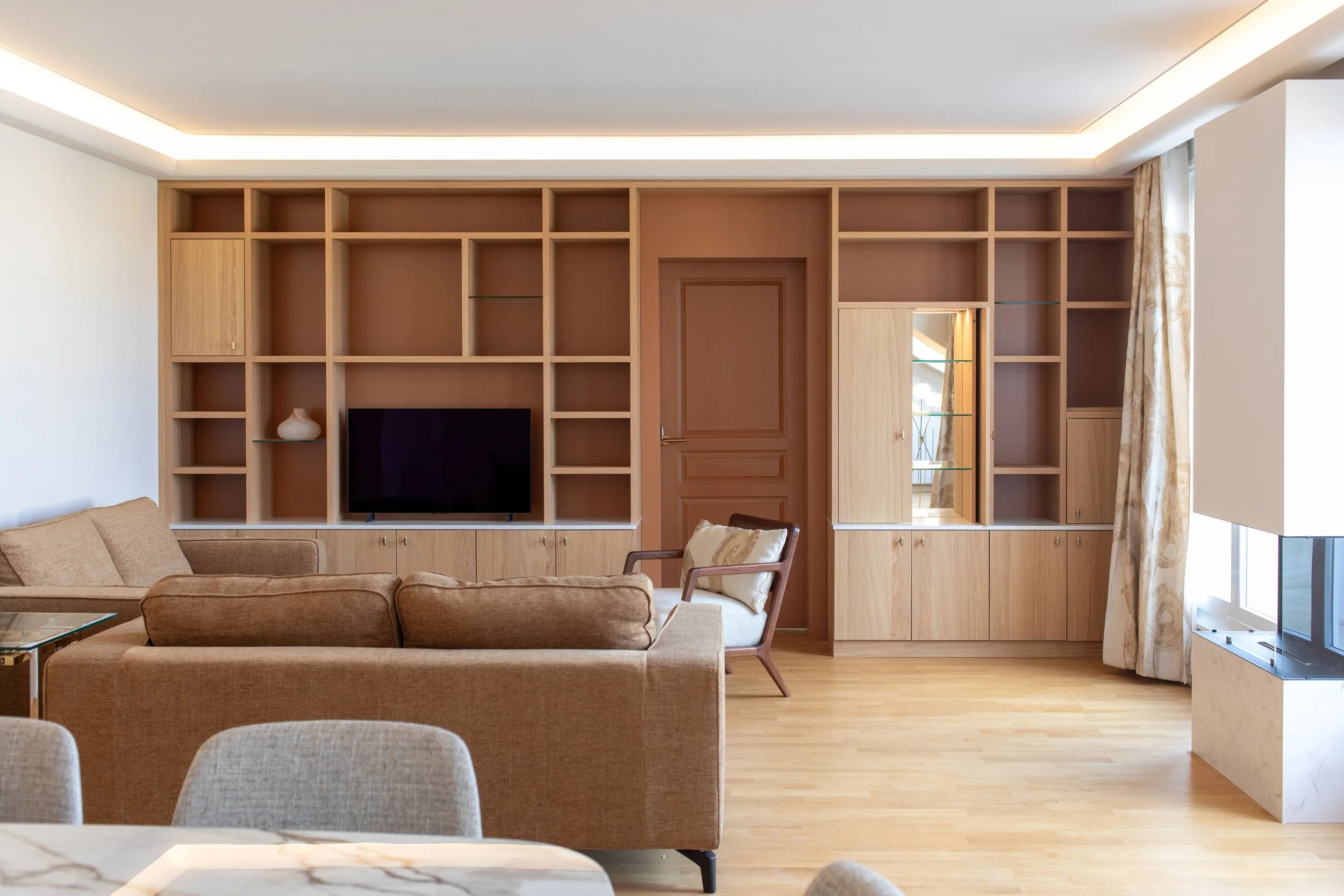 Bibliothèque chêne fond terracotta bar miroir éclairage indirect cheminée ethanol