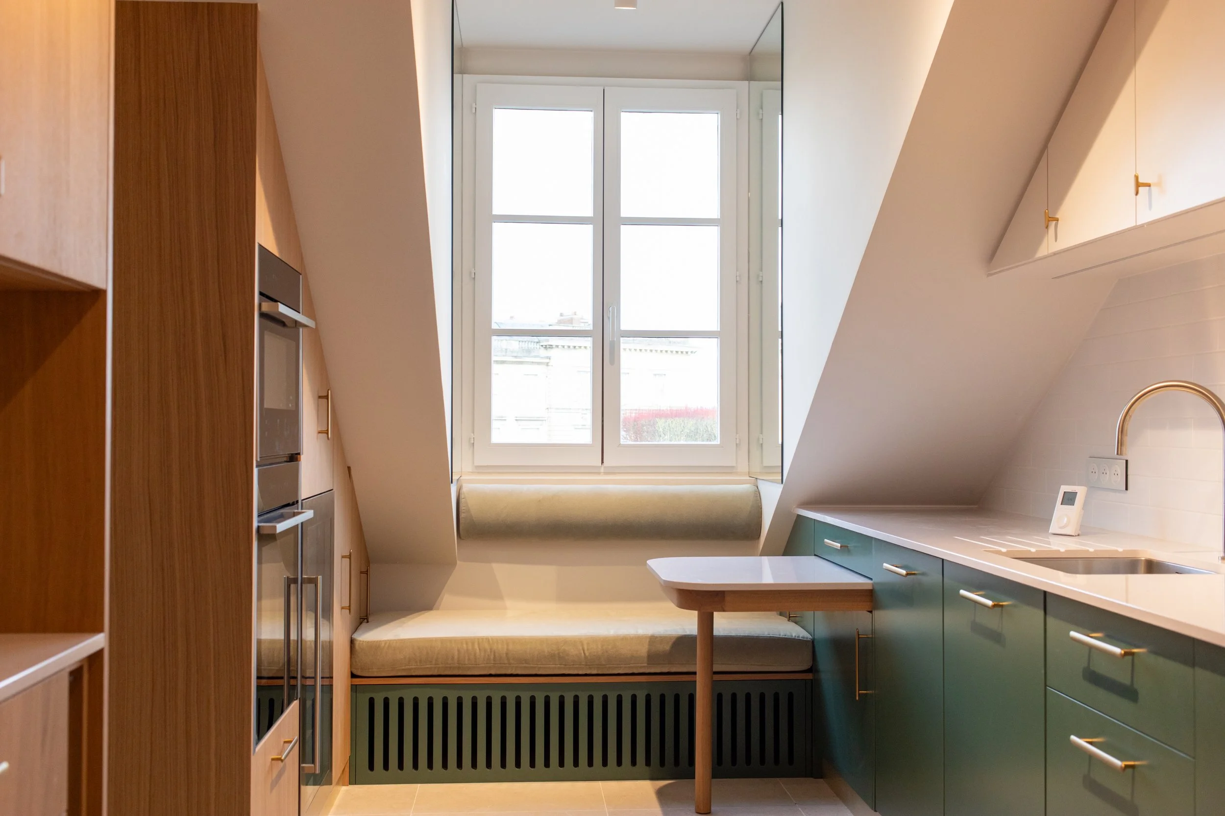 cuisine sous rampants vert et chêne banquette sous lucarne et table rétractable