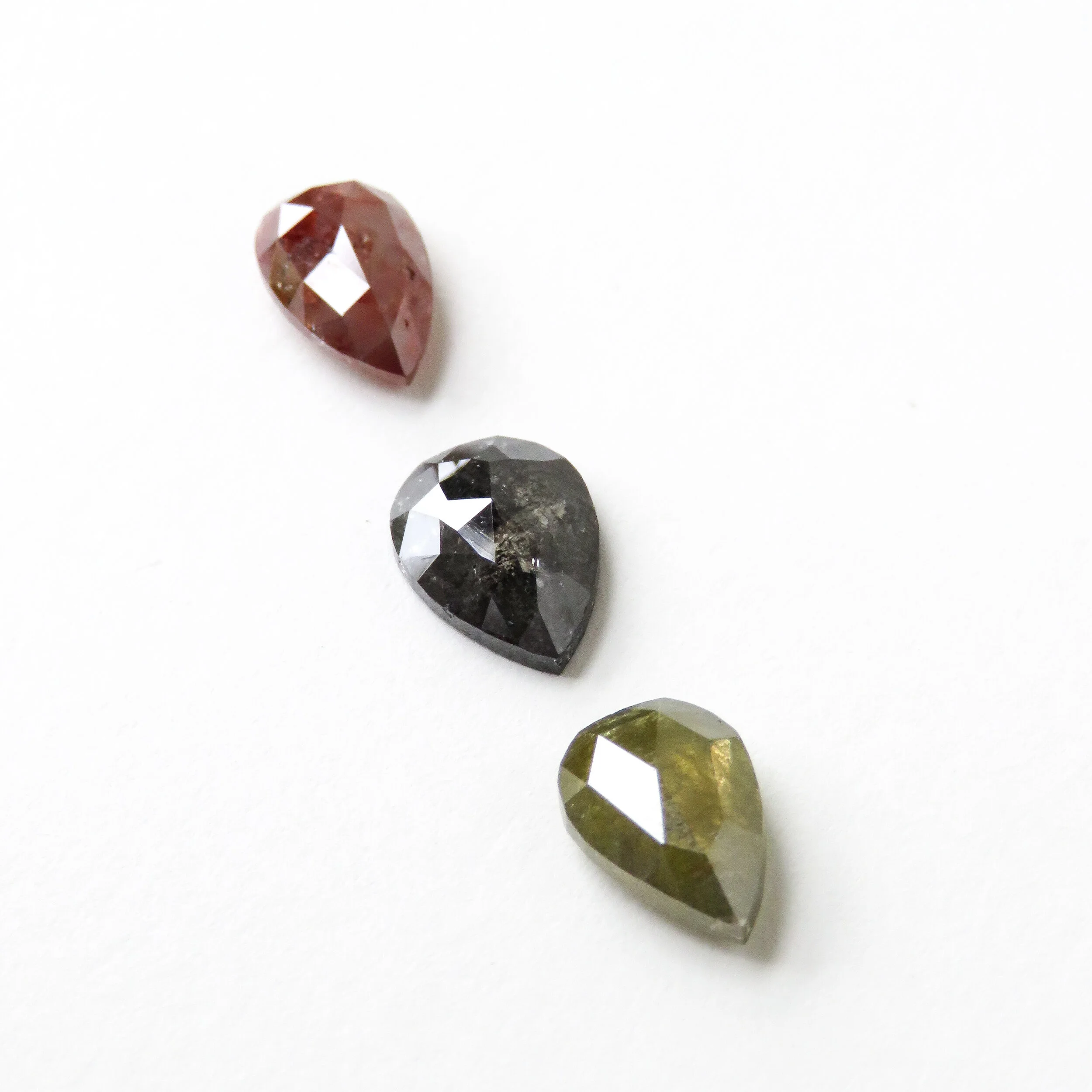 three different colour diamonds in red, grey and green
