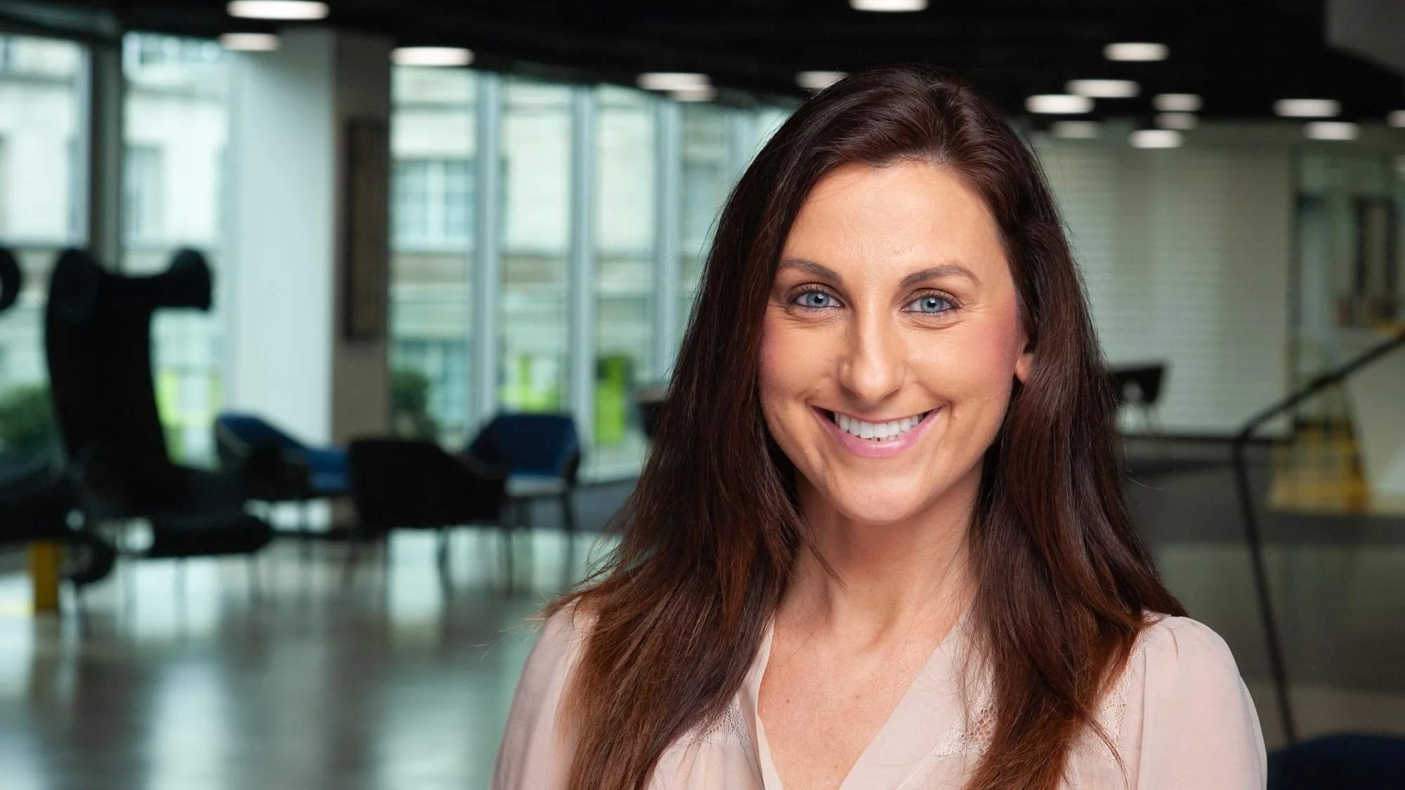 Individual headshot of a female executive in an office lobby