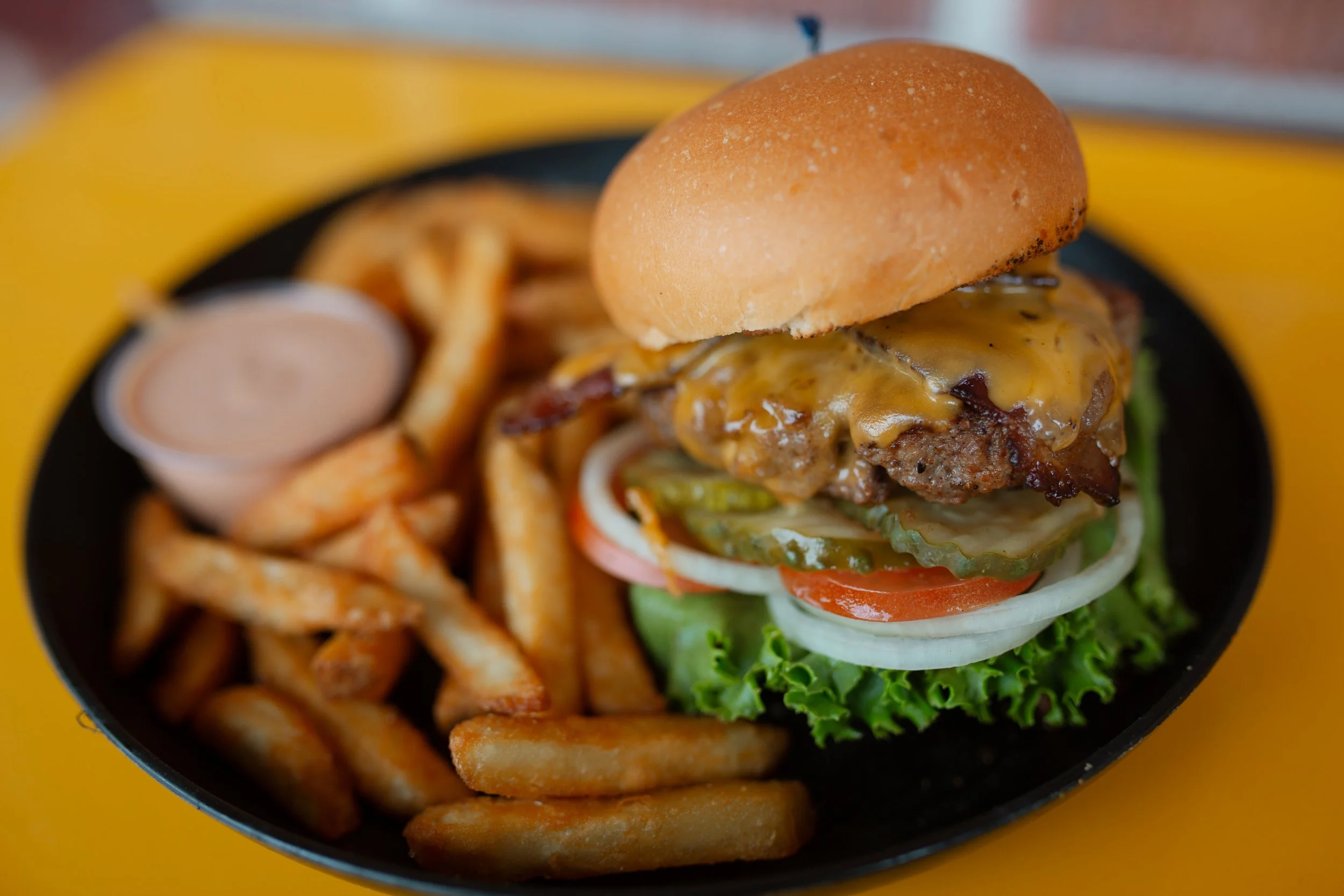 Cheese burger with all the toppings, fries and fry sauce