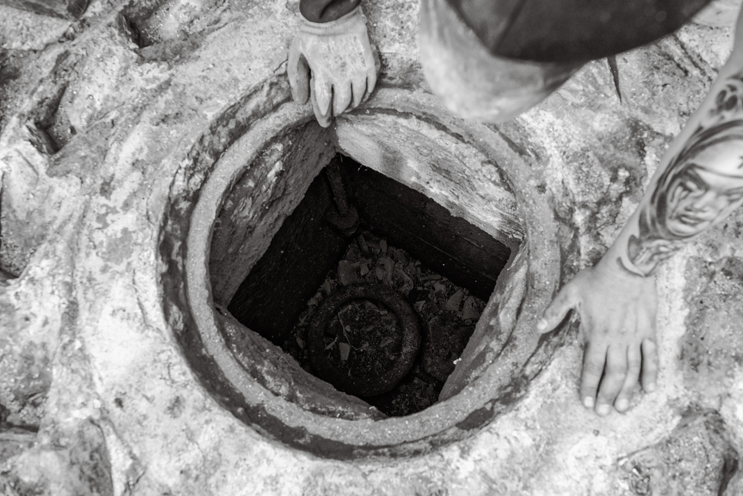 Workers look into a hole where the gearing mechanism for a steam powered capstan might have sat as part of the heritage project to replace the capstans on Whitby Harbour.