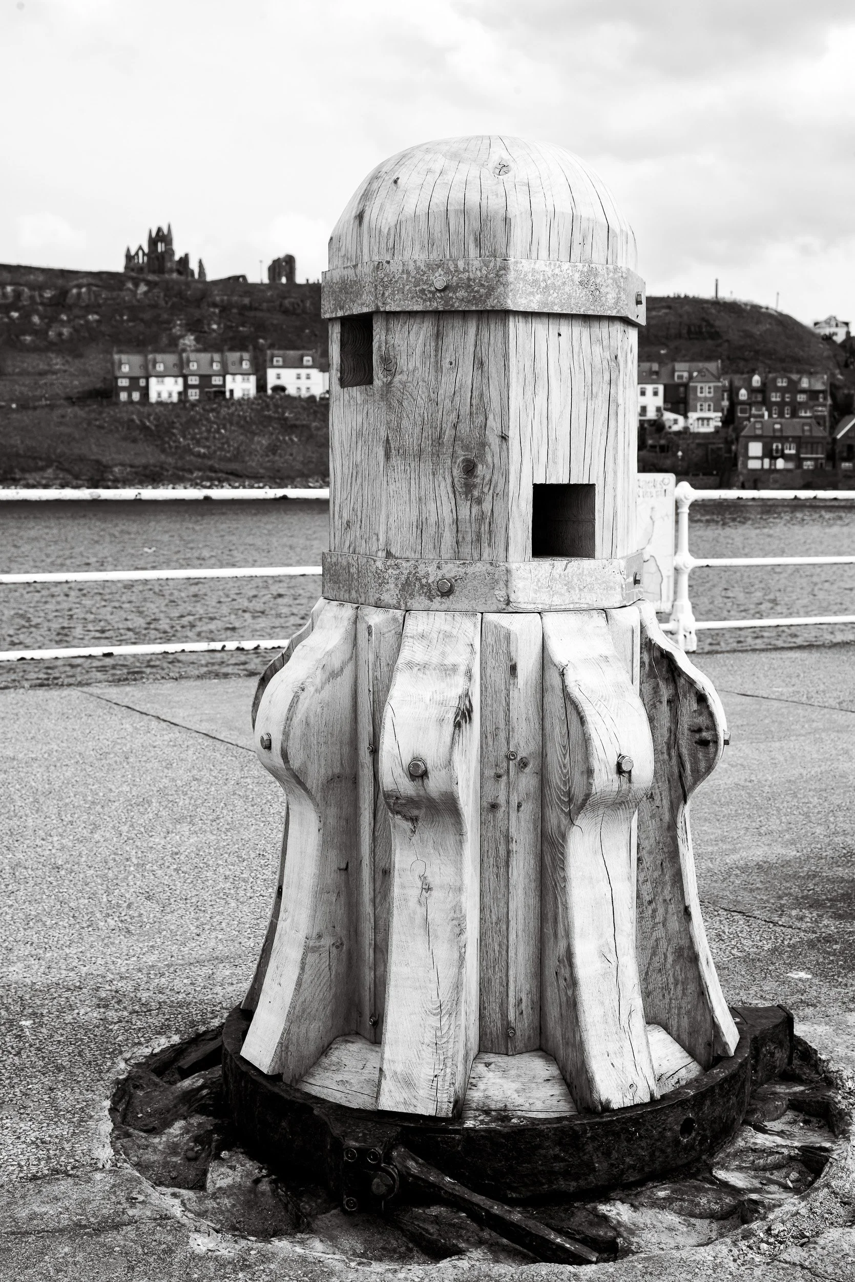 A completed handcrafted timber capstan sits on the pier with Whitby Abbey in the background as part of the heritage project to replace the capstans on Whitby Harbour.