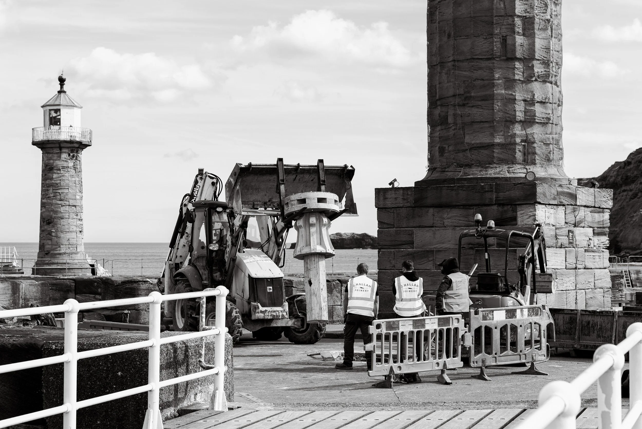 Joiners from J Hallam Joinery look on as an excavator carefully lifts a handcrafted timber capstan into place on the harbour at Whitby as part of the heritage project to replace the capstans on Whitby Harbour.