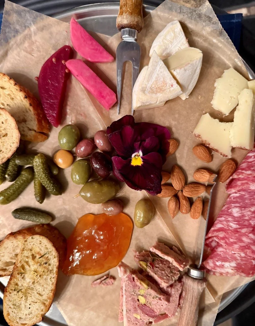 Le Sud charcuterie board with cured meats, cheeses, olives, cornichons and jam