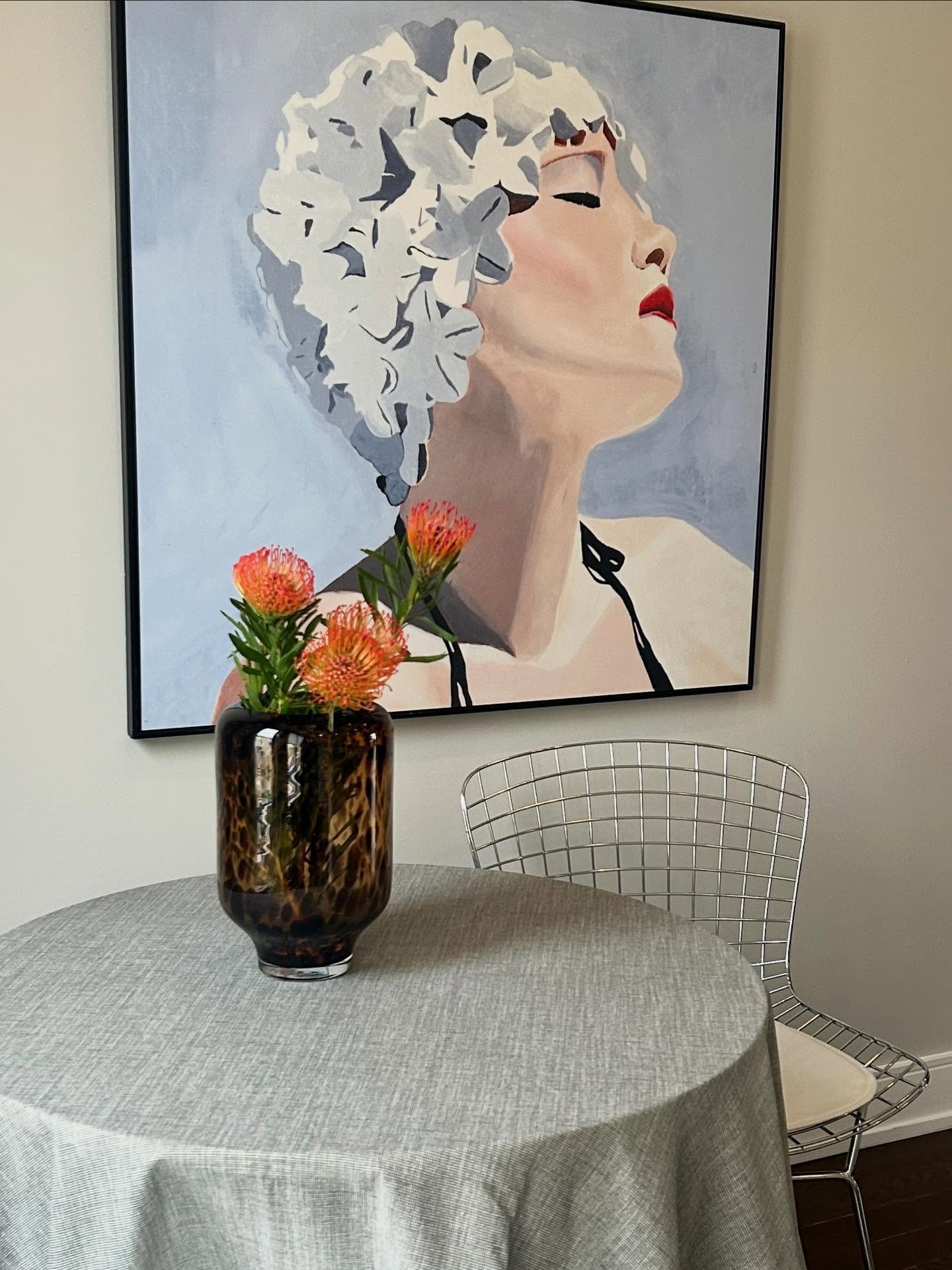 We loved the idea of pairing these Bertoia chairs with something a bit more elegant, like this tortoise-glass vase. The pincushion flowers add a beautiful pop of color and contrast perfectly with the cool tones of the blue painting.