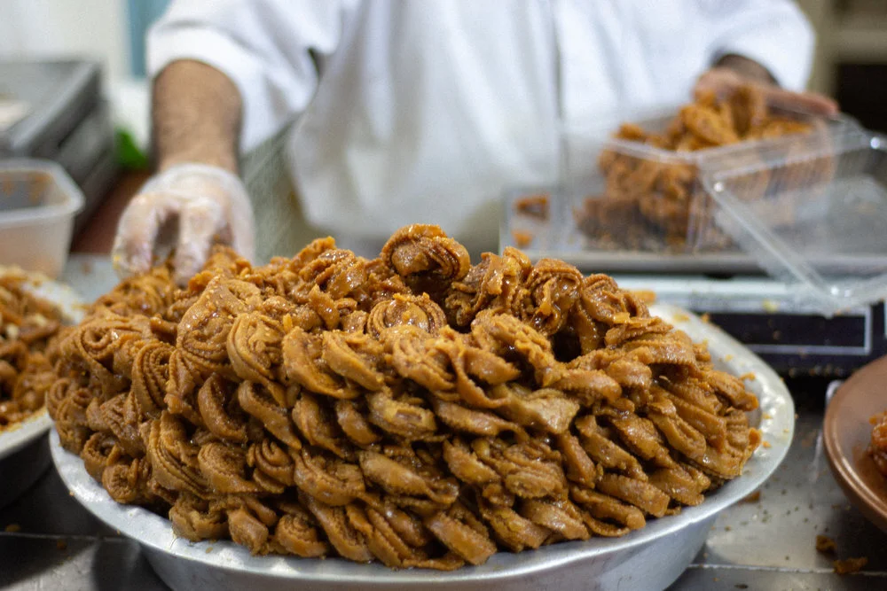 A baker boxes honey drizzled almond pastries