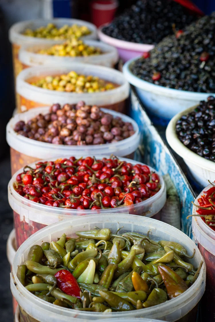 Buckets filled with soaked peppers and olives