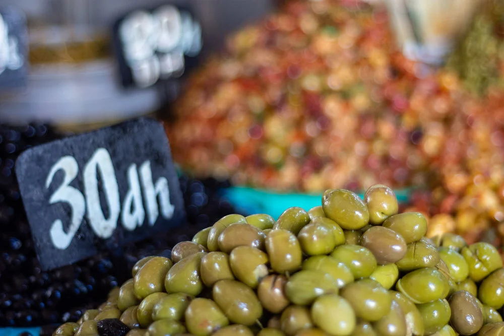 Fragrant mounds of green and cured black olives permeate the market